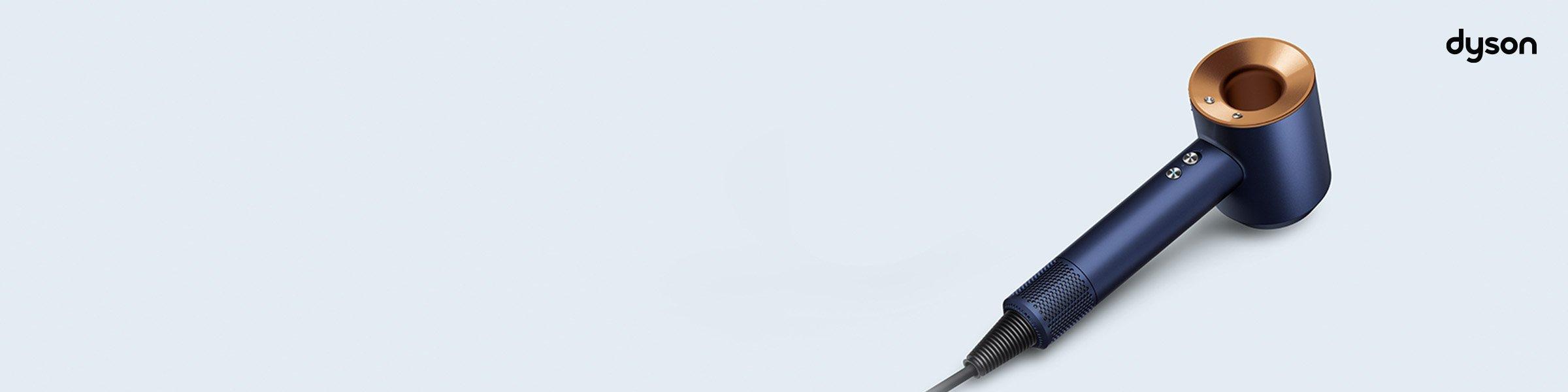 Dyson Supersonic hair dryer in blue and copper, displayed on a light background with Dyson logo