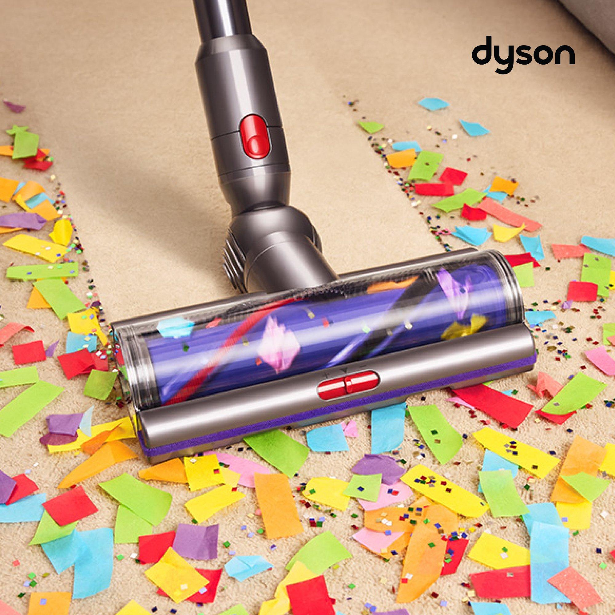 Dyson vacuum cleaning colorful confetti from a carpet