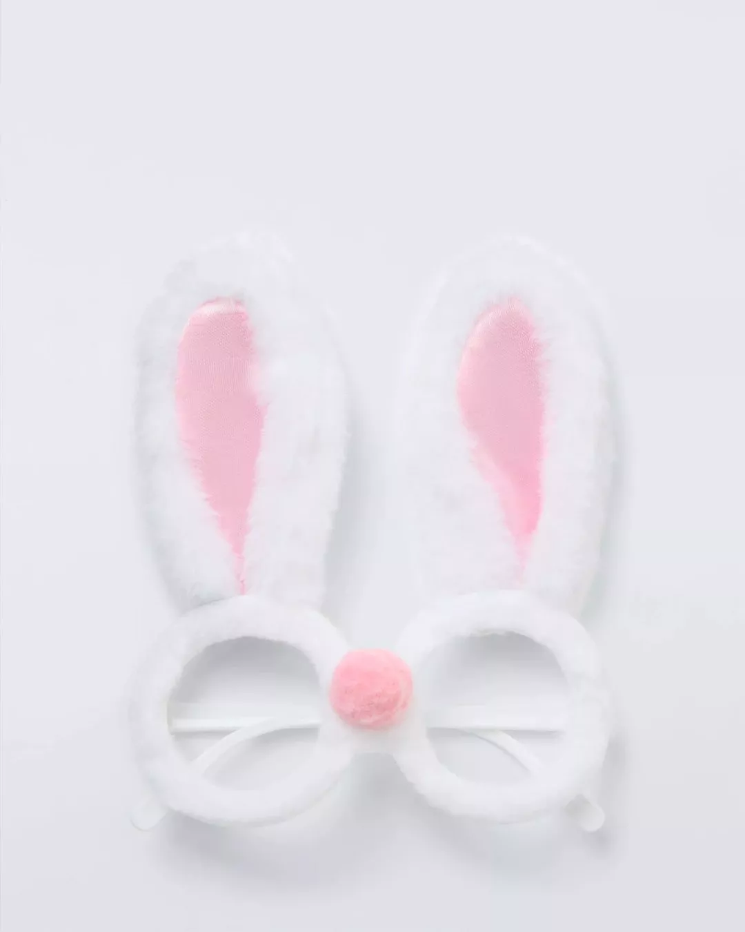 White bunny ear glasses with pink inner ears and a fluffy pink nose on a white background. Fun costume accessory.