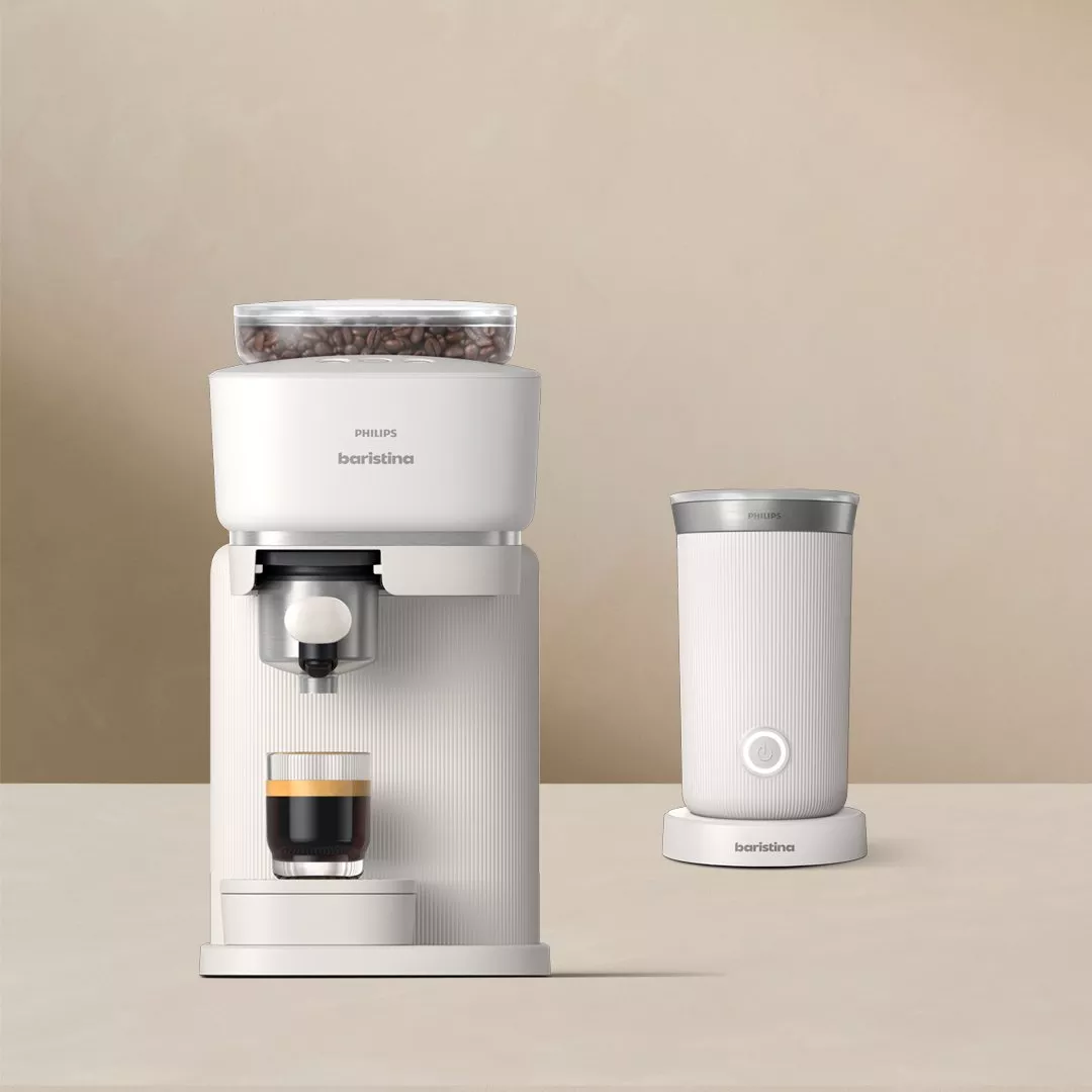 Modern coffee machine and frother set on a beige background, showcasing sleek design and functionality.