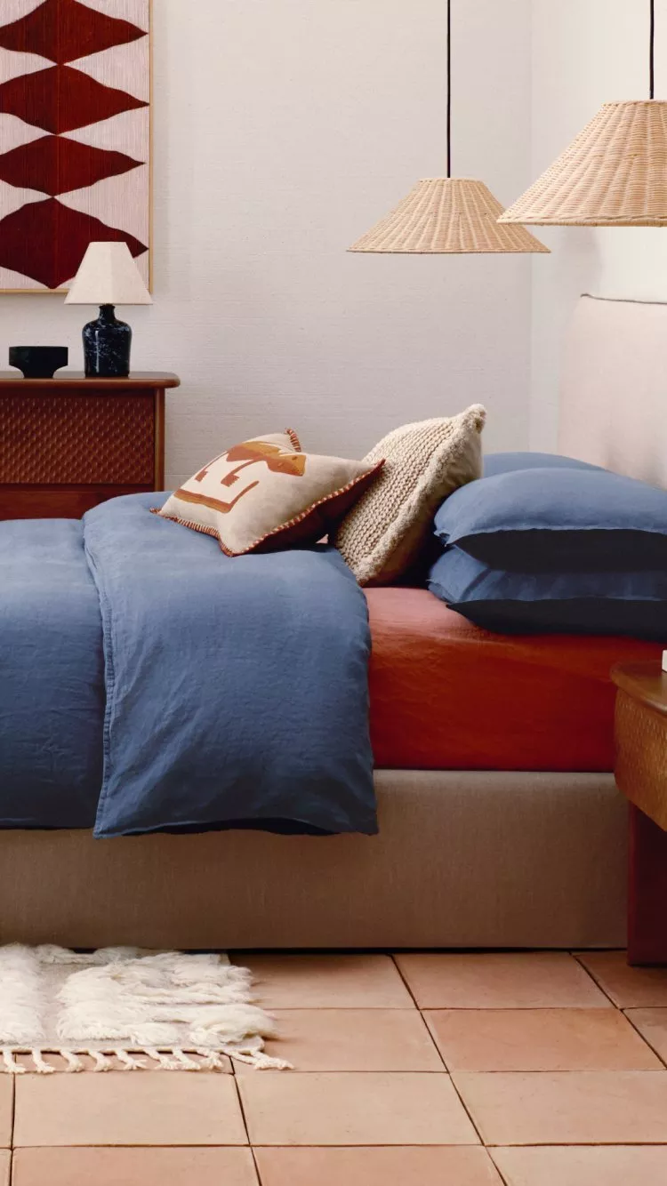 a room with a bed dressed in colourful bohemian style 