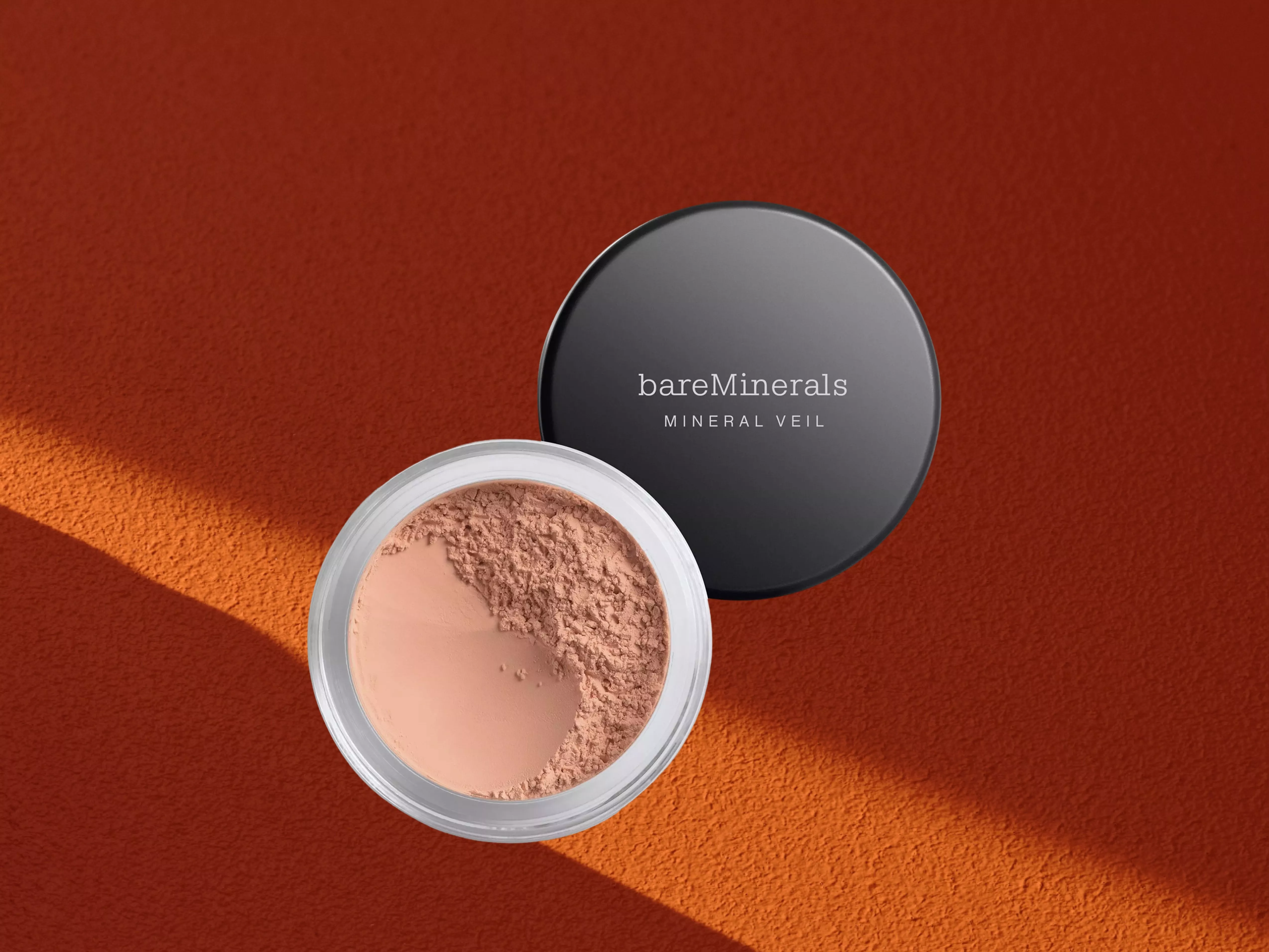 bareMinerals MINERAL VEIL Setting Powder on a orange background