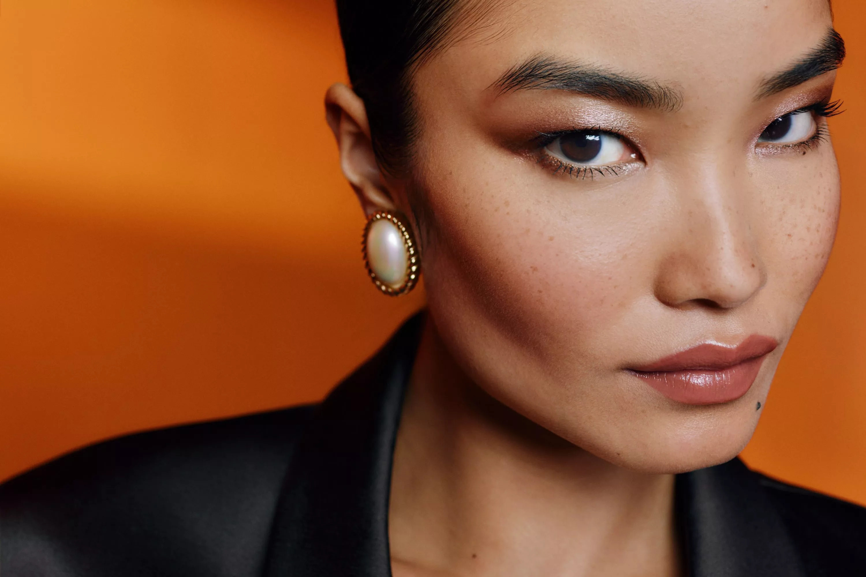 a model wiht a orange background behind her