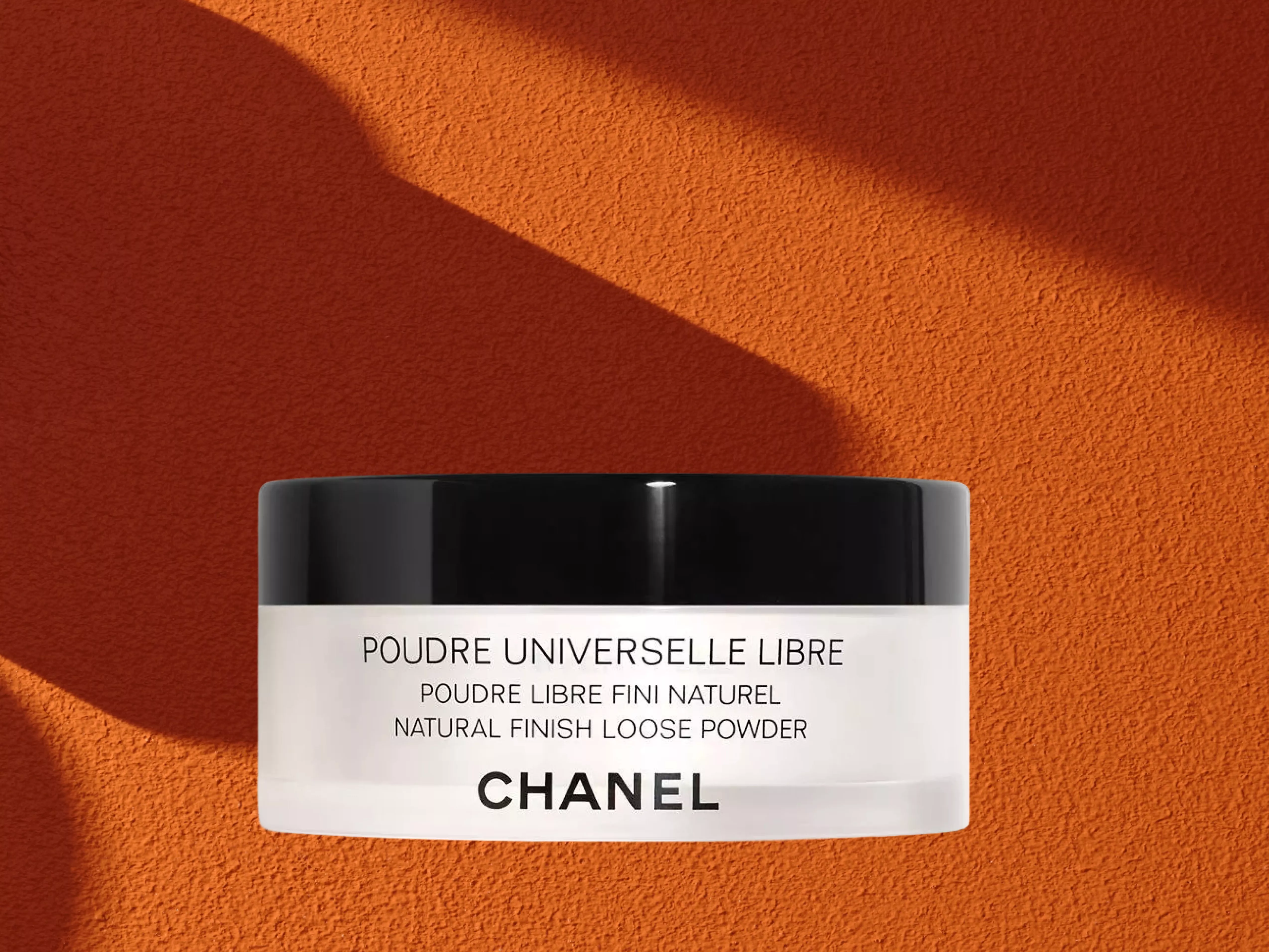 CHANEL Poudre Universel Libre Natural Finish Loose Powder on a orange background