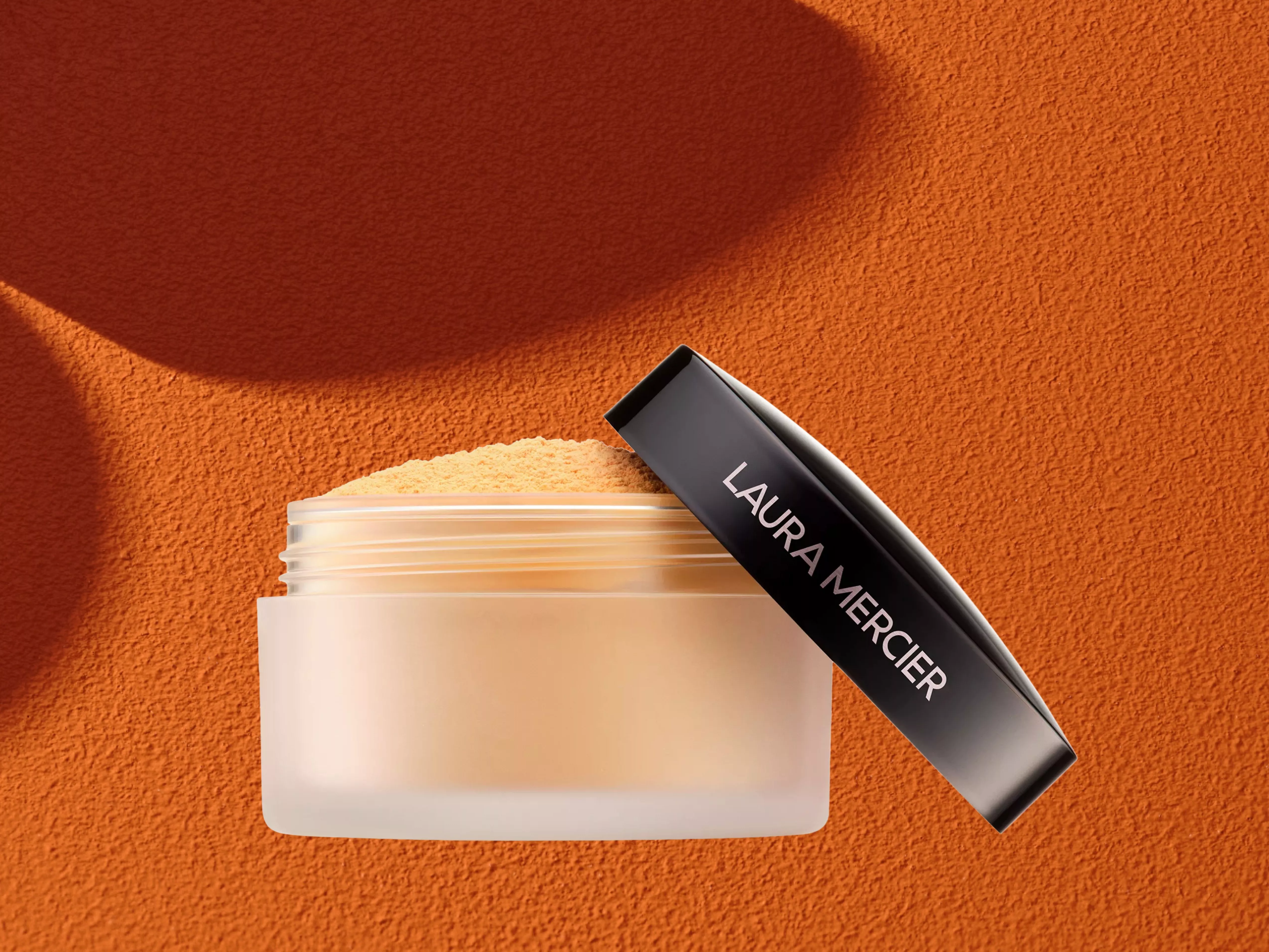 Laura Mercier Under Eye Setting Powder on a orange background