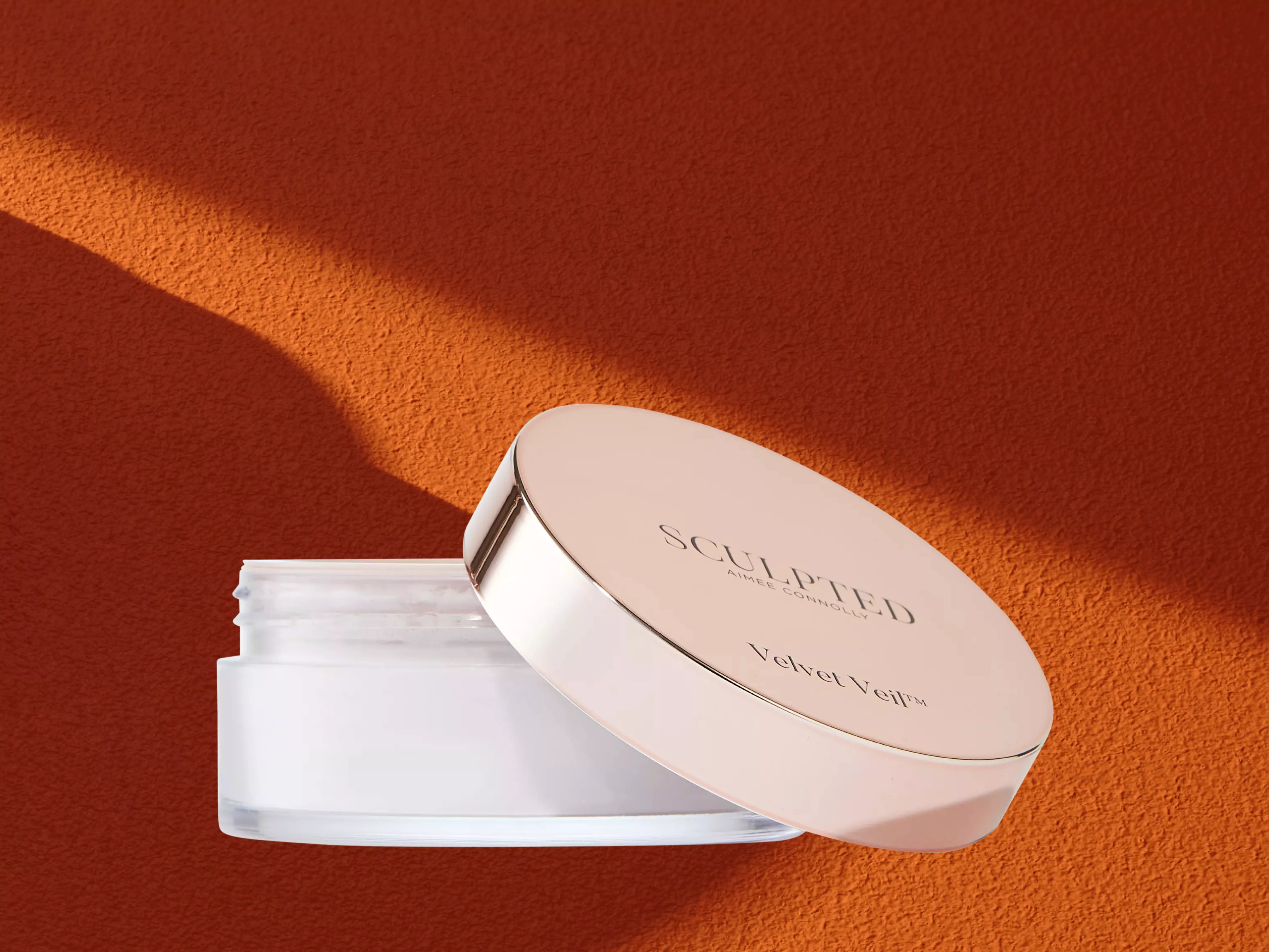 Sculpted By Aimee Velvet Veil™ Loose Setting Powder on a orange background