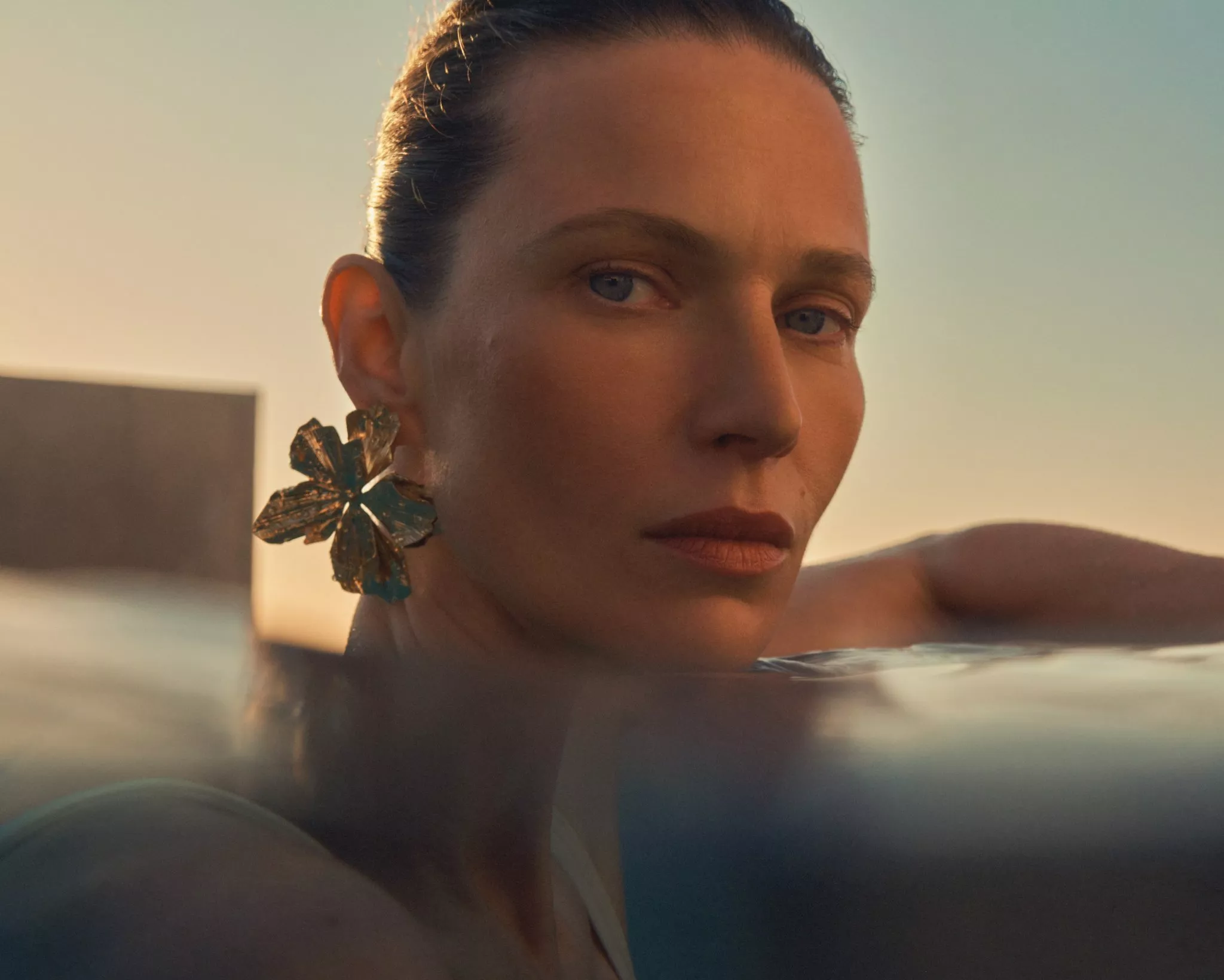 women wearing makeup in a swimming pool with sunset behind