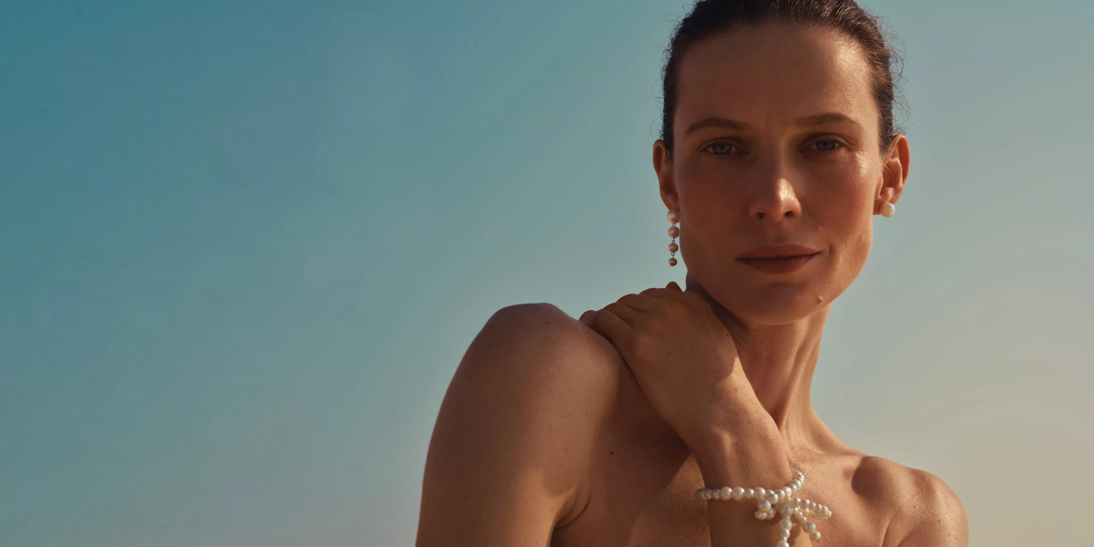 women holding her hand on her shoulder in sunshine 