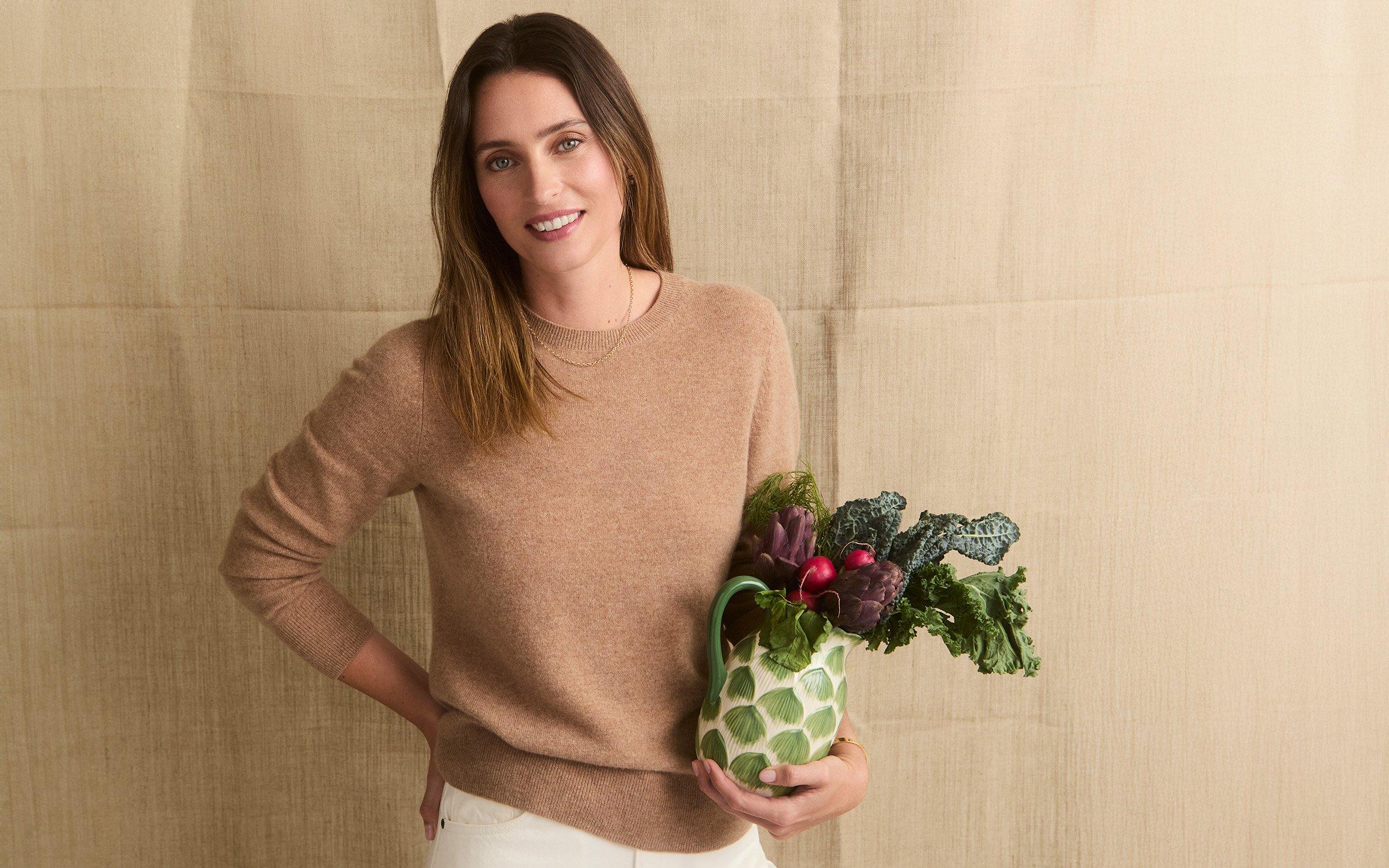 Ella Woddward holding a jug of vegetable leaves
