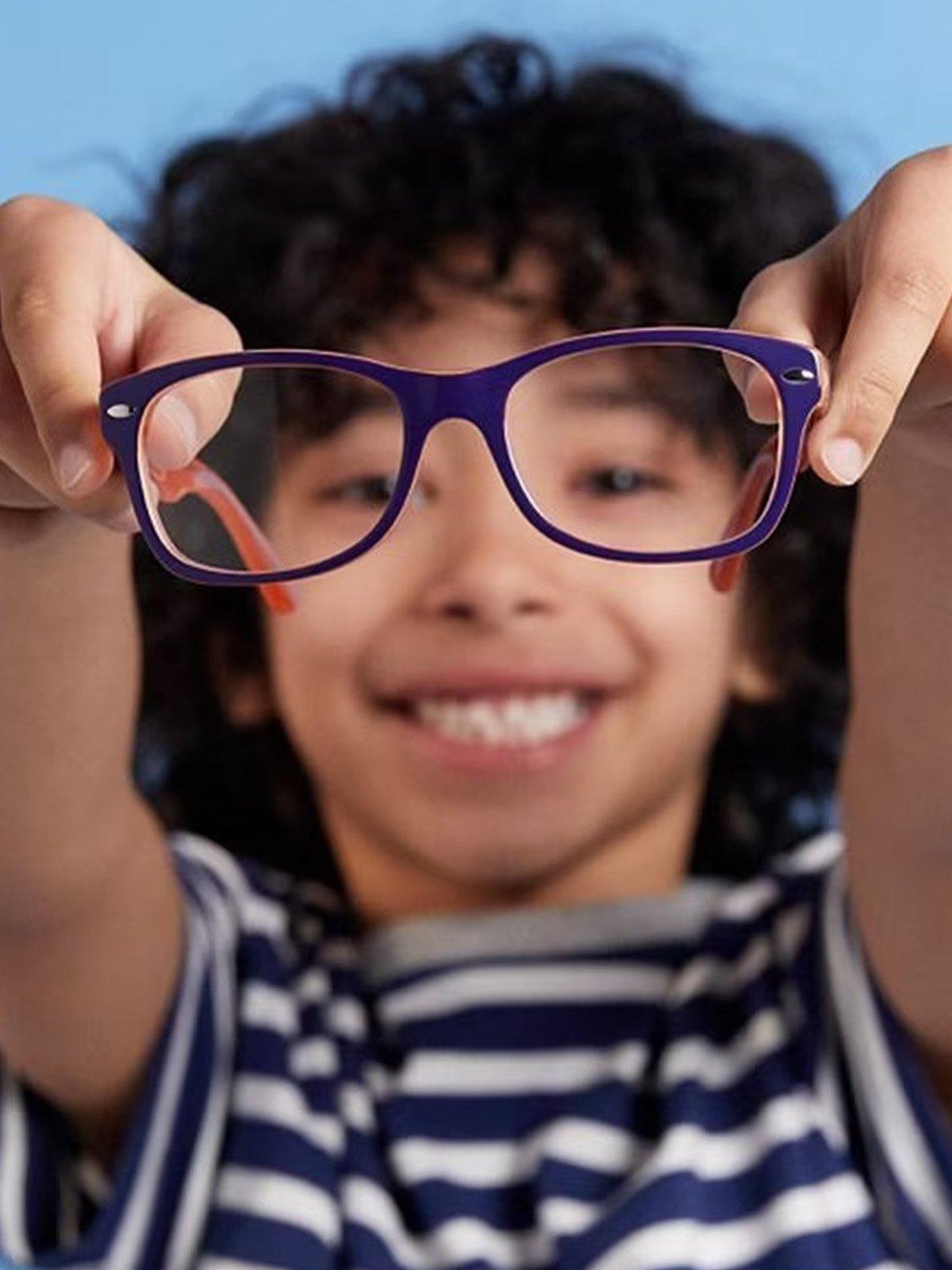 Boy holding up glasses