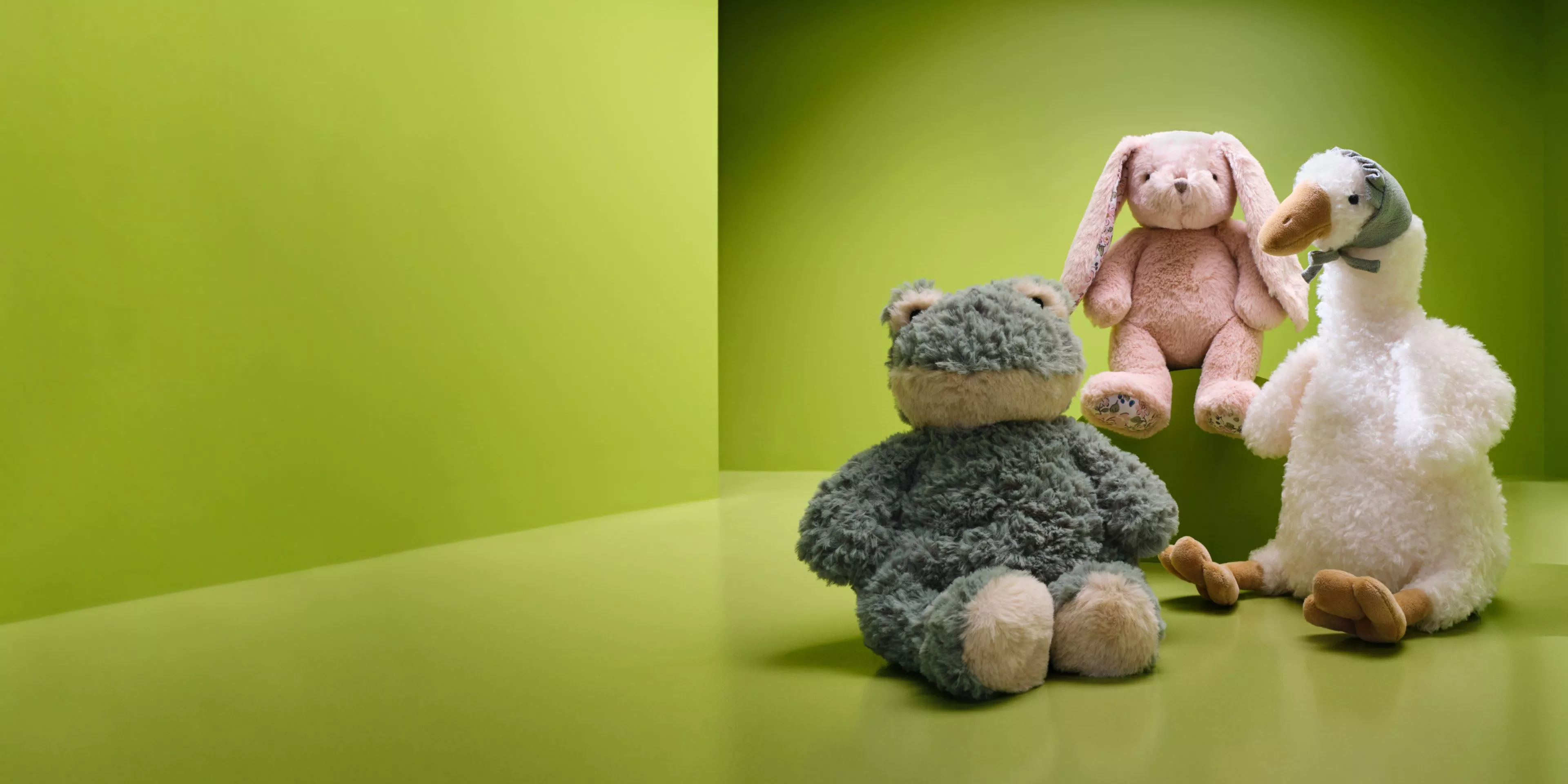 Soft toy rabbit, teddy bear and plush duck on green background, cute nursery décor and children’s gift ideas