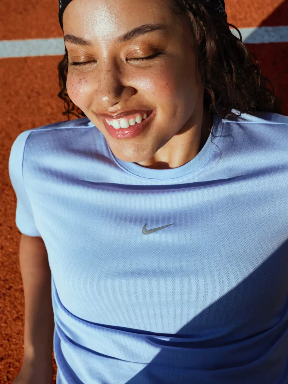 Athletic woman sprinting up stadium steps in pink sports top, outdoor fitness training workout session