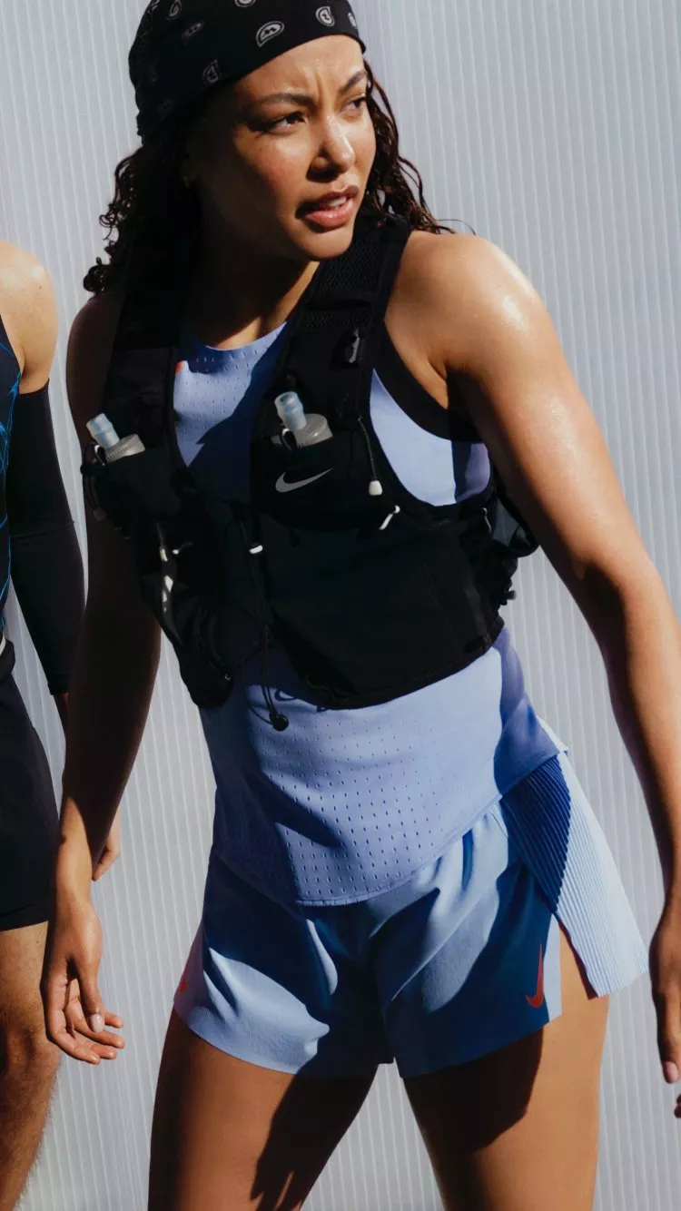 man and women wearing nike gear infron of a metal wall