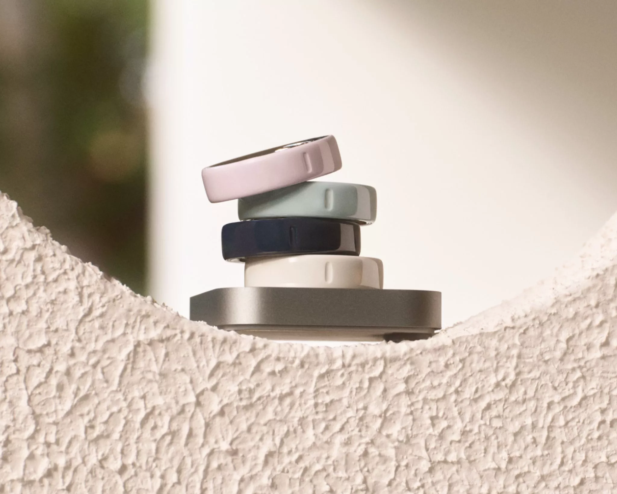 smart rings sitting on a cream wall
