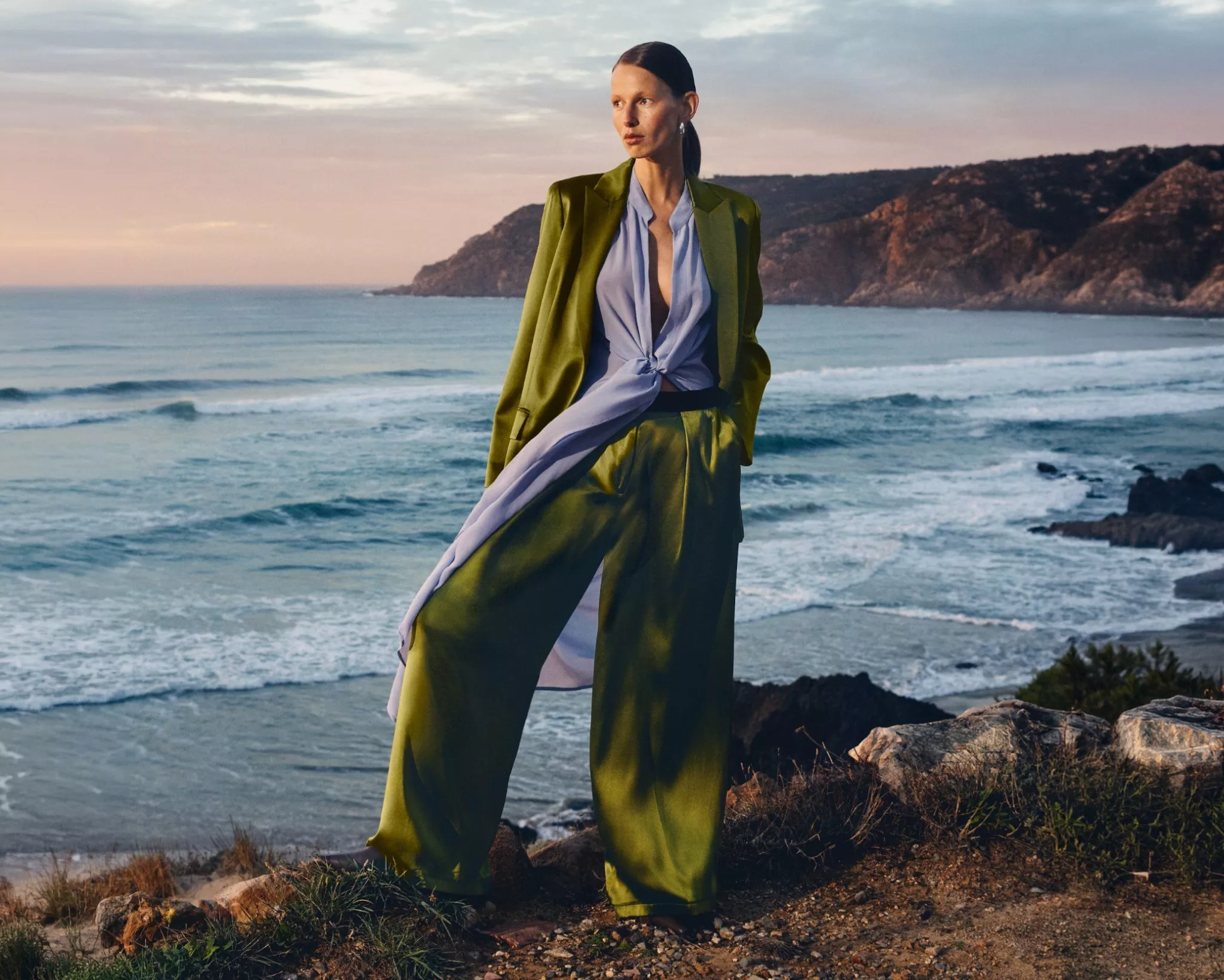 women wearing a green suit with a beach behind it
