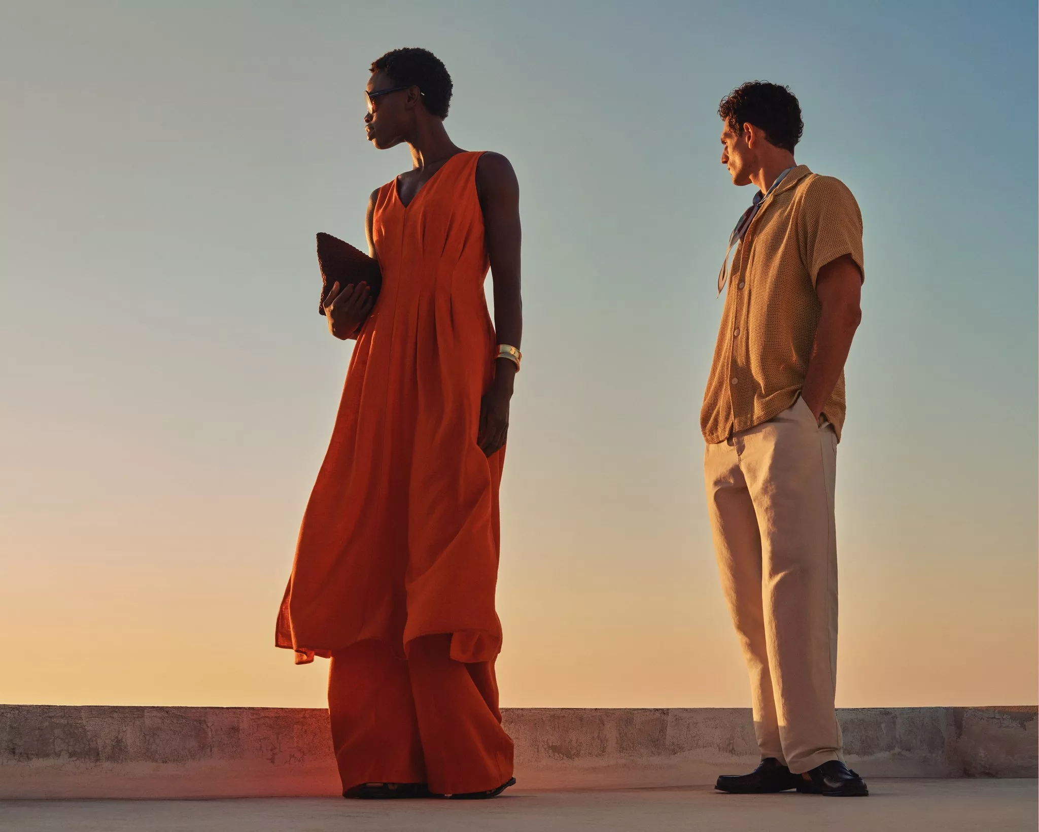 women and a man dressed in smart clothing looking out at a sunny landscape