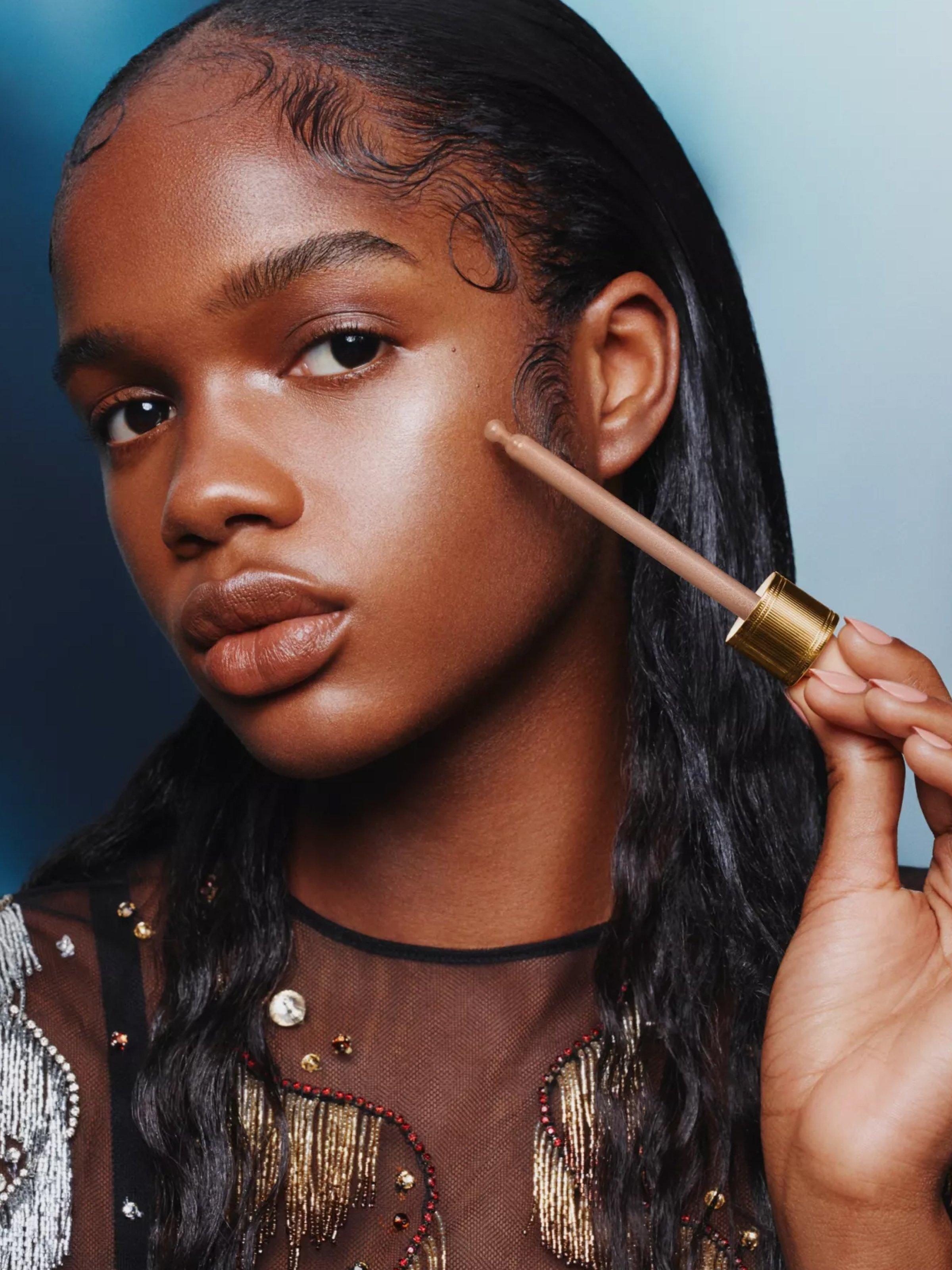 A model with Gucci Beauty Illuminateur de Beauté Liquid Highlighter