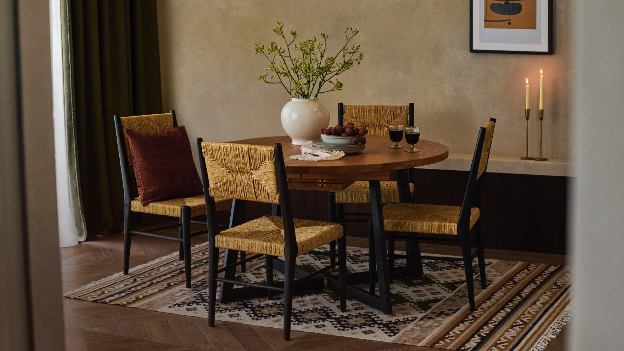 a dining table, chairs, and home accessories displayed in a dining room