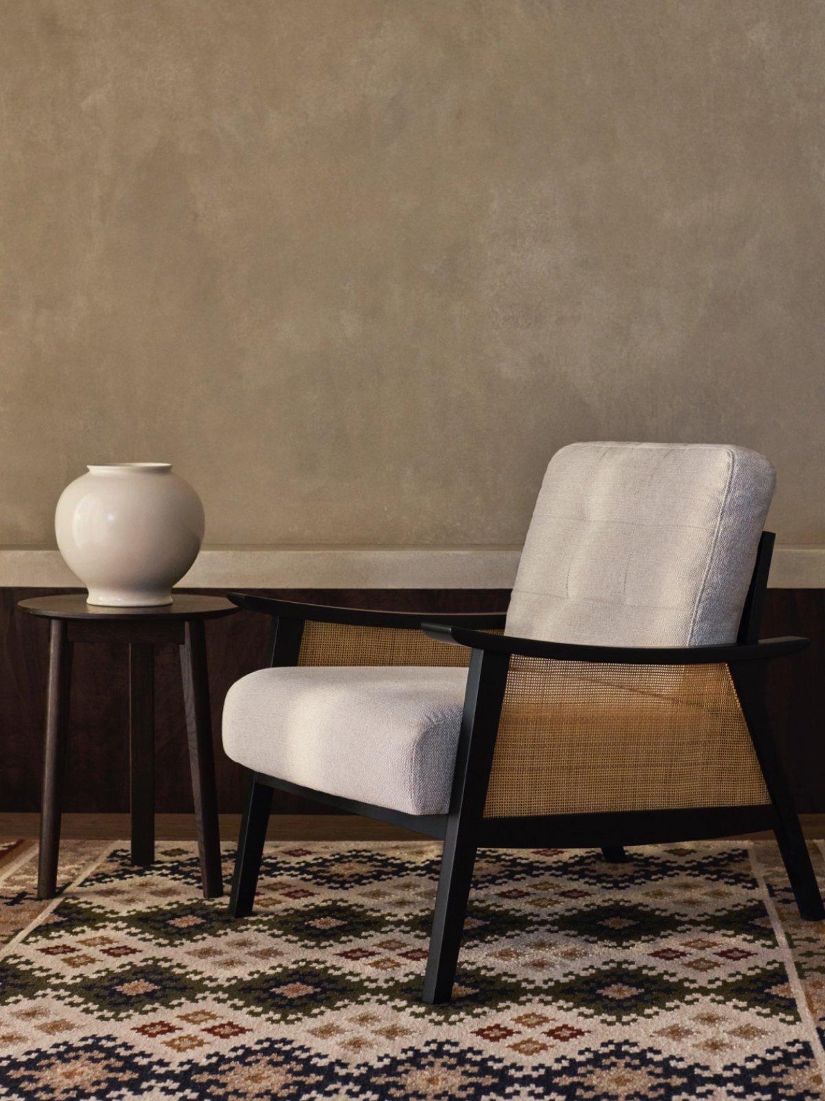 White porcelain on a side table and a wooden armchair displayed