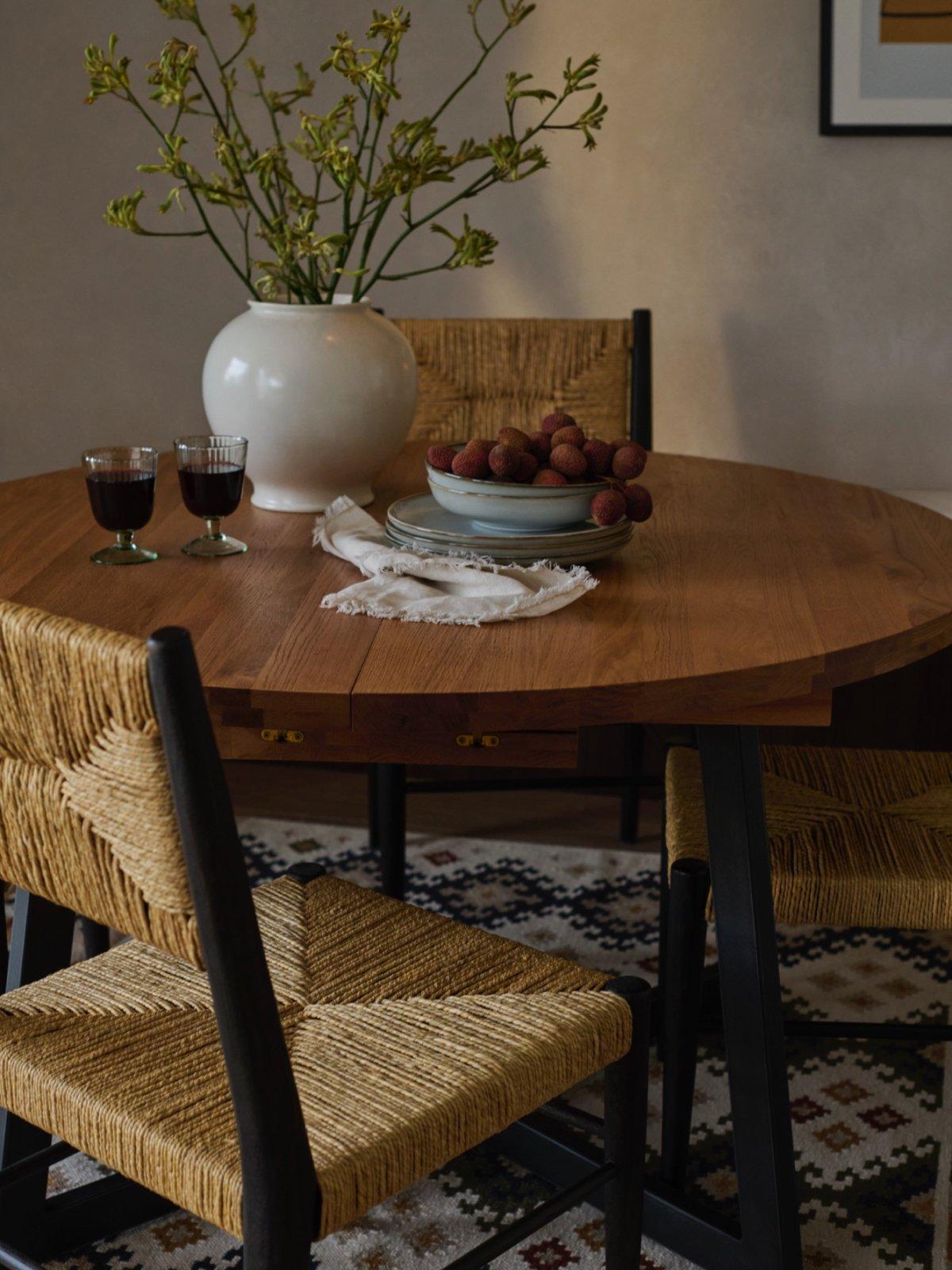A wooden dining table and dining chairs displayed with homeware accessories in a dining room setting