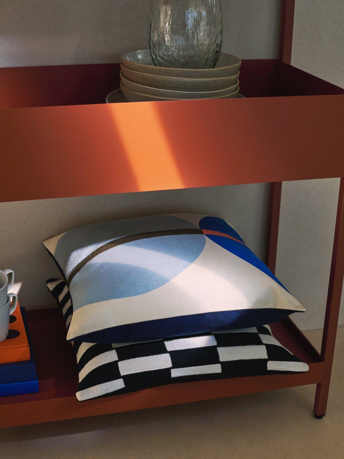 Scandi cushions and crockery on a stand-alone shelf unit