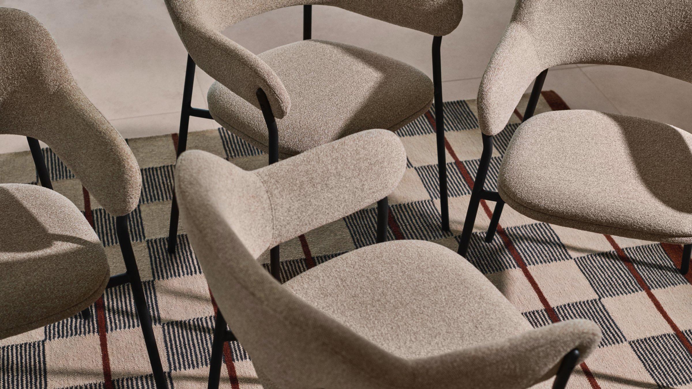 Multiple Scandi chairs on a checkered patterned carpet