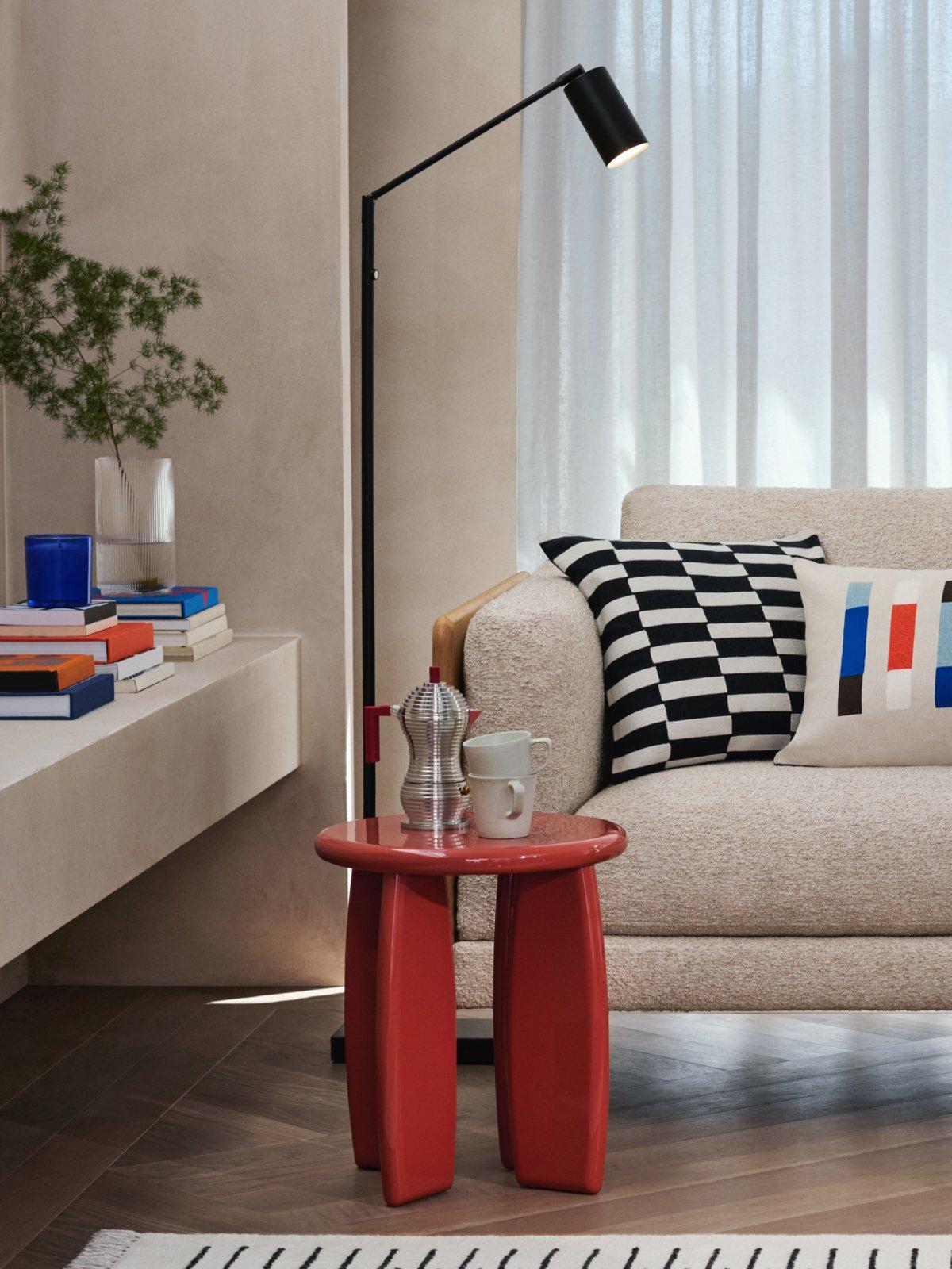 Scandi off white sofa, orange side table and tall lamp in a lounge area