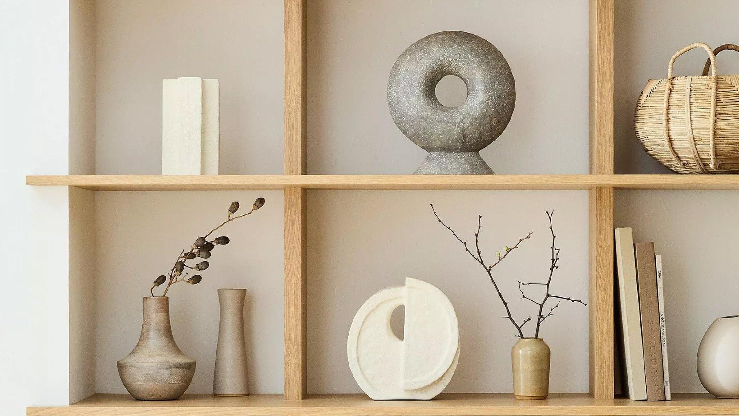 Selection of objects and books displayed on wooden shelving