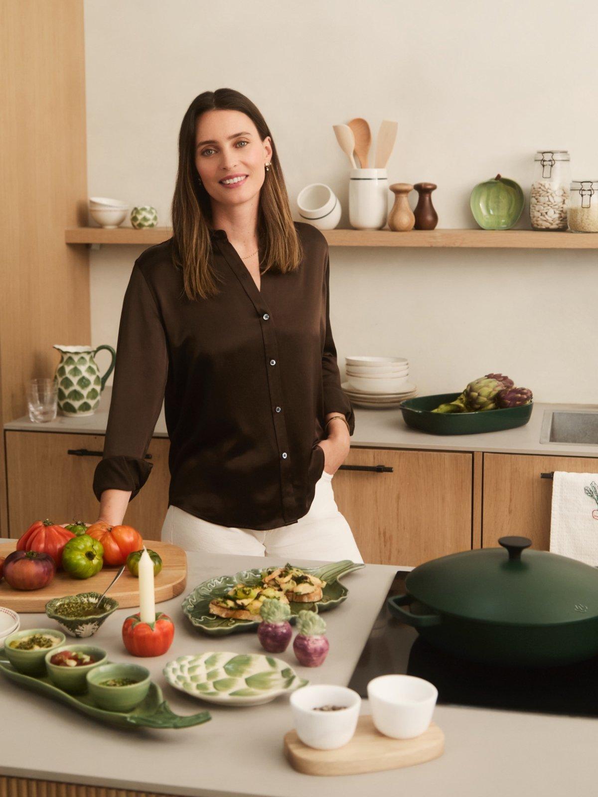 Ella standing behind a table displaying a variety of John Lewis X Deliciously Ella homeware products