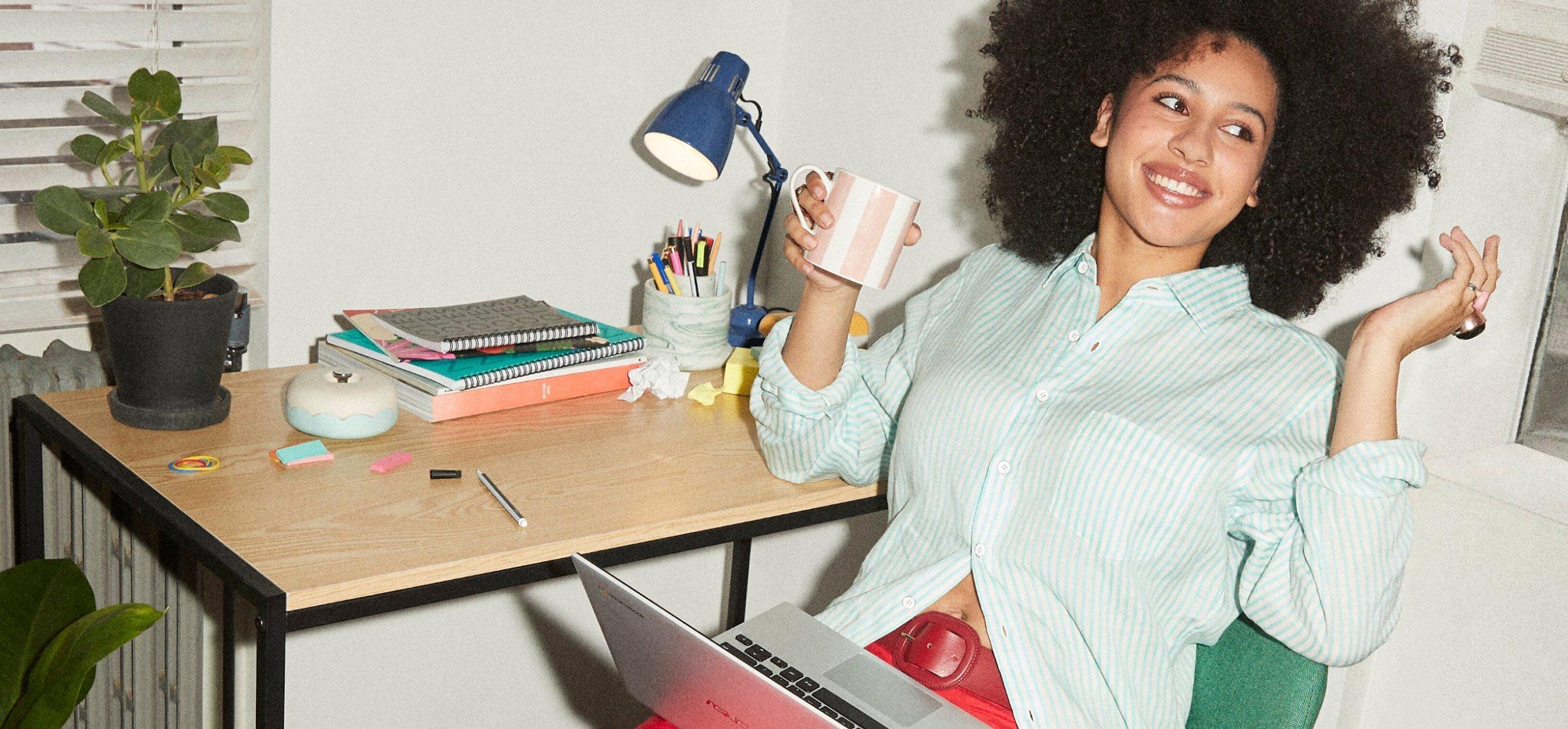 Image of a girl with a laptop on her lap sitting with her feet up on a table