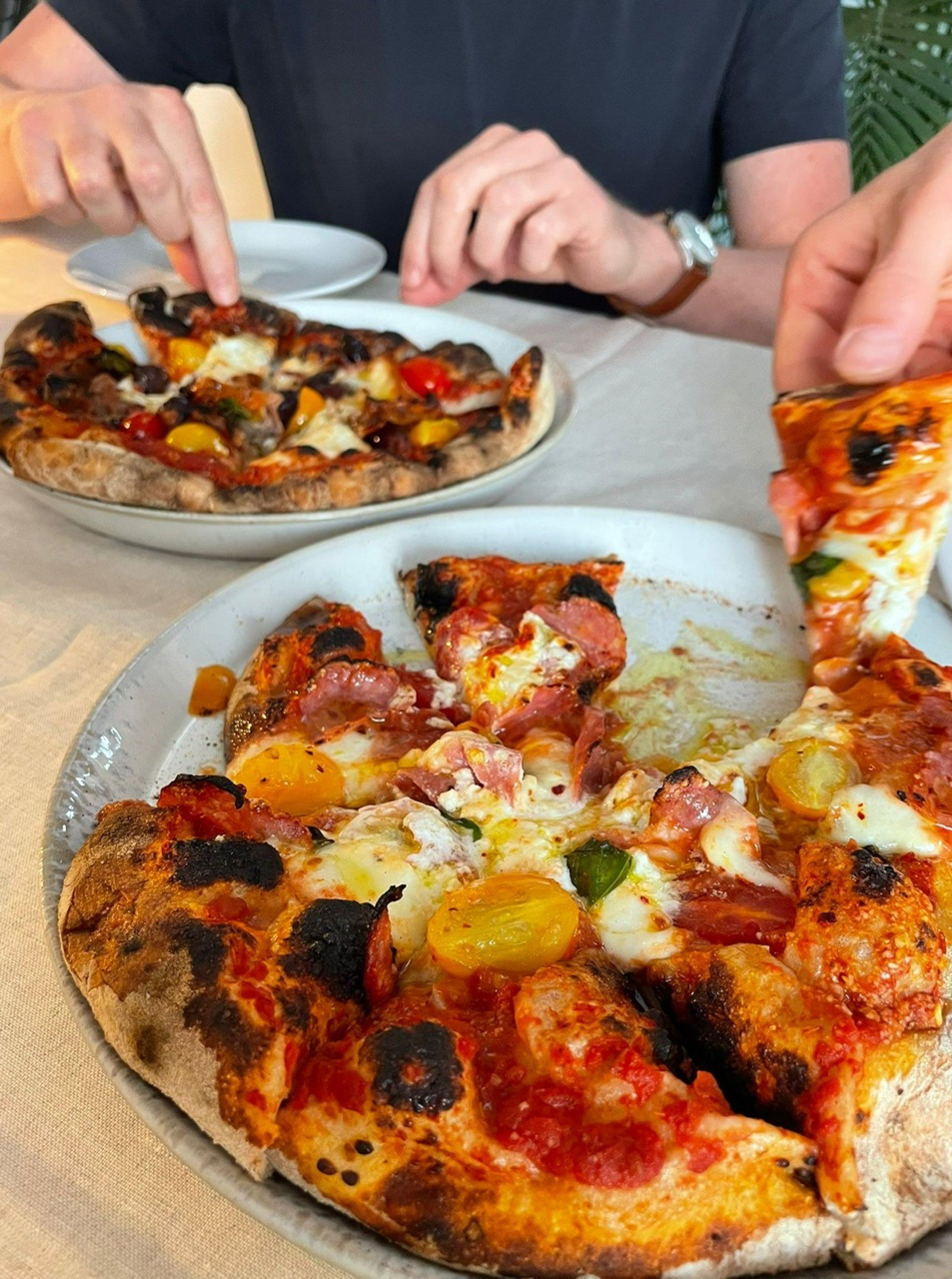Pizza made with the Ninja Artisan Electric Outdoor Pizza & Air Fry Oven, placed on plates