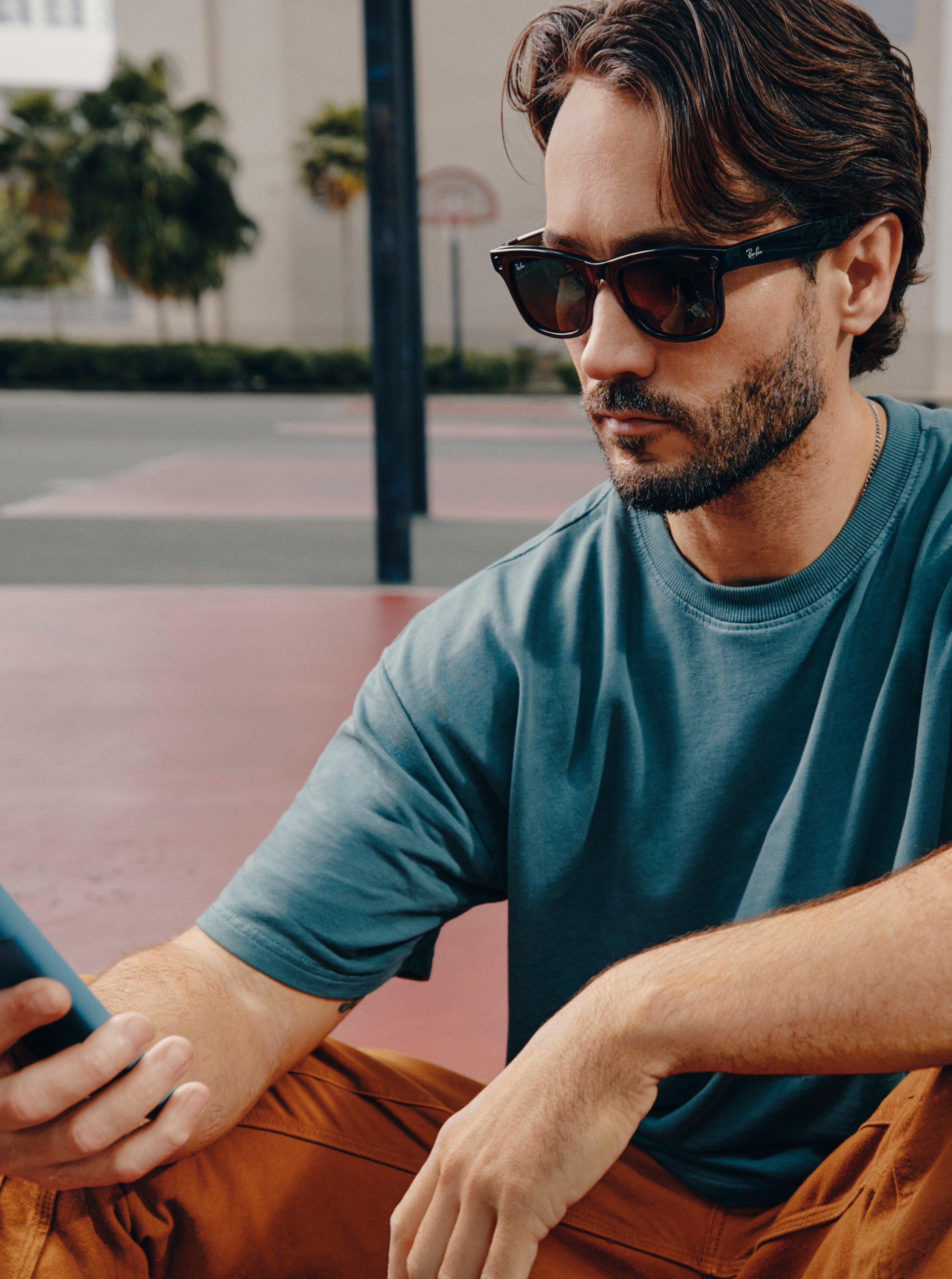 Male model wearing Ray-Ban Meta Glasses on a tennis court