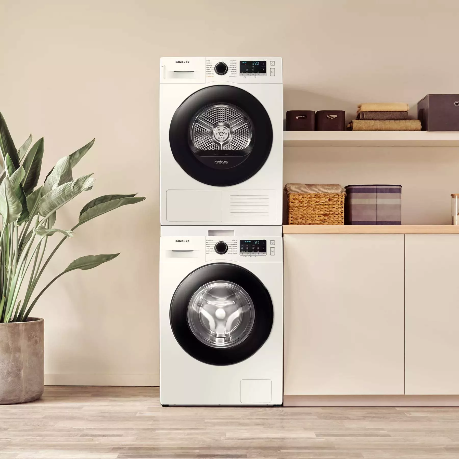 Stacked Samsung washer and heat pump dryer in modern laundry room with shelves, baskets and houseplant.