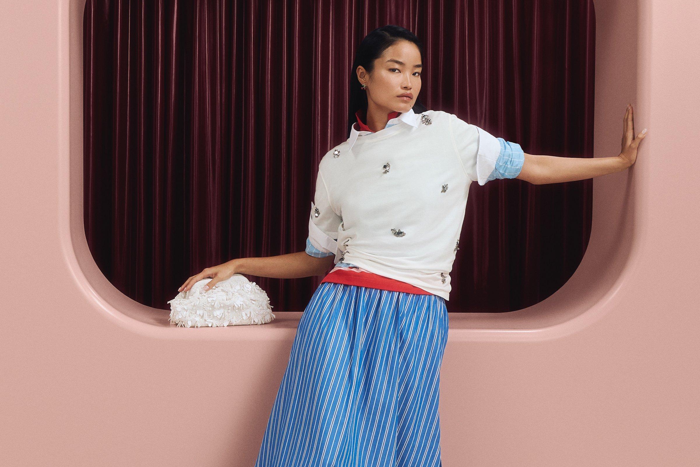 Image of a lady wearing a white blouse and blue skirt