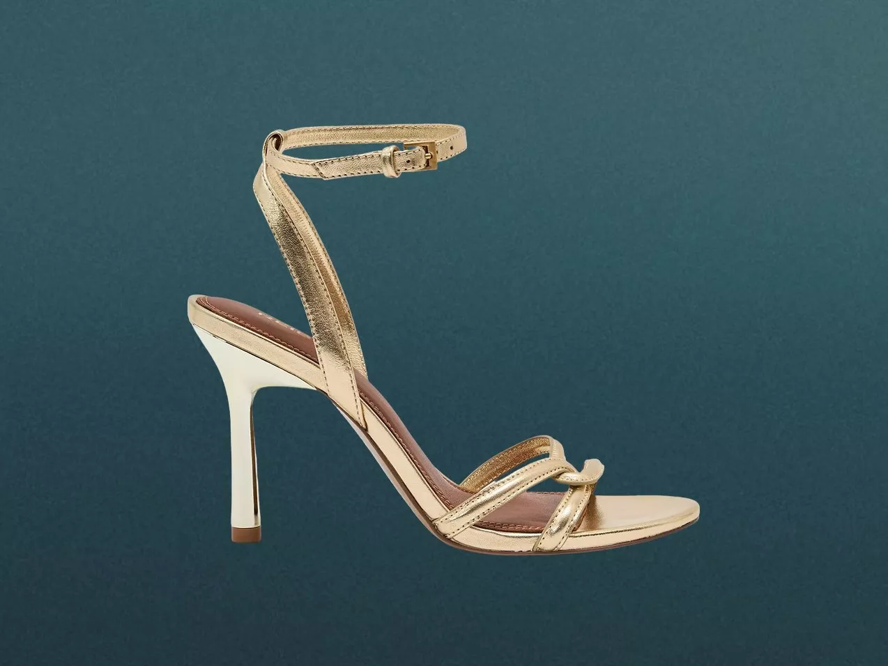 Gold strappy stiletto heel sandal with ankle buckle strap, on blue background