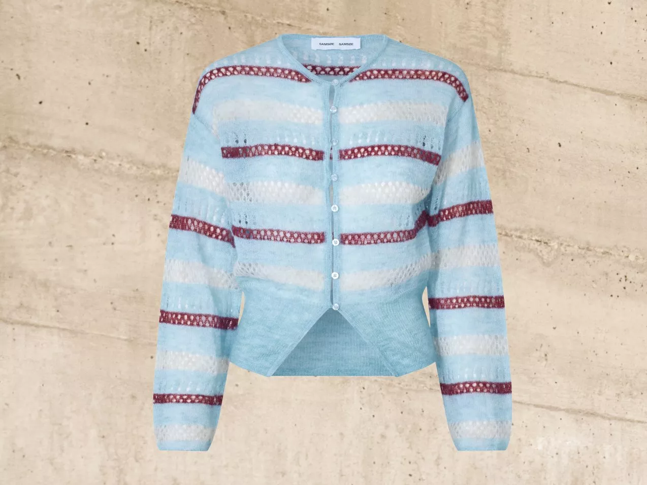 Light blue striped cardigan with red accents on a textured beige background, featuring button closure.
