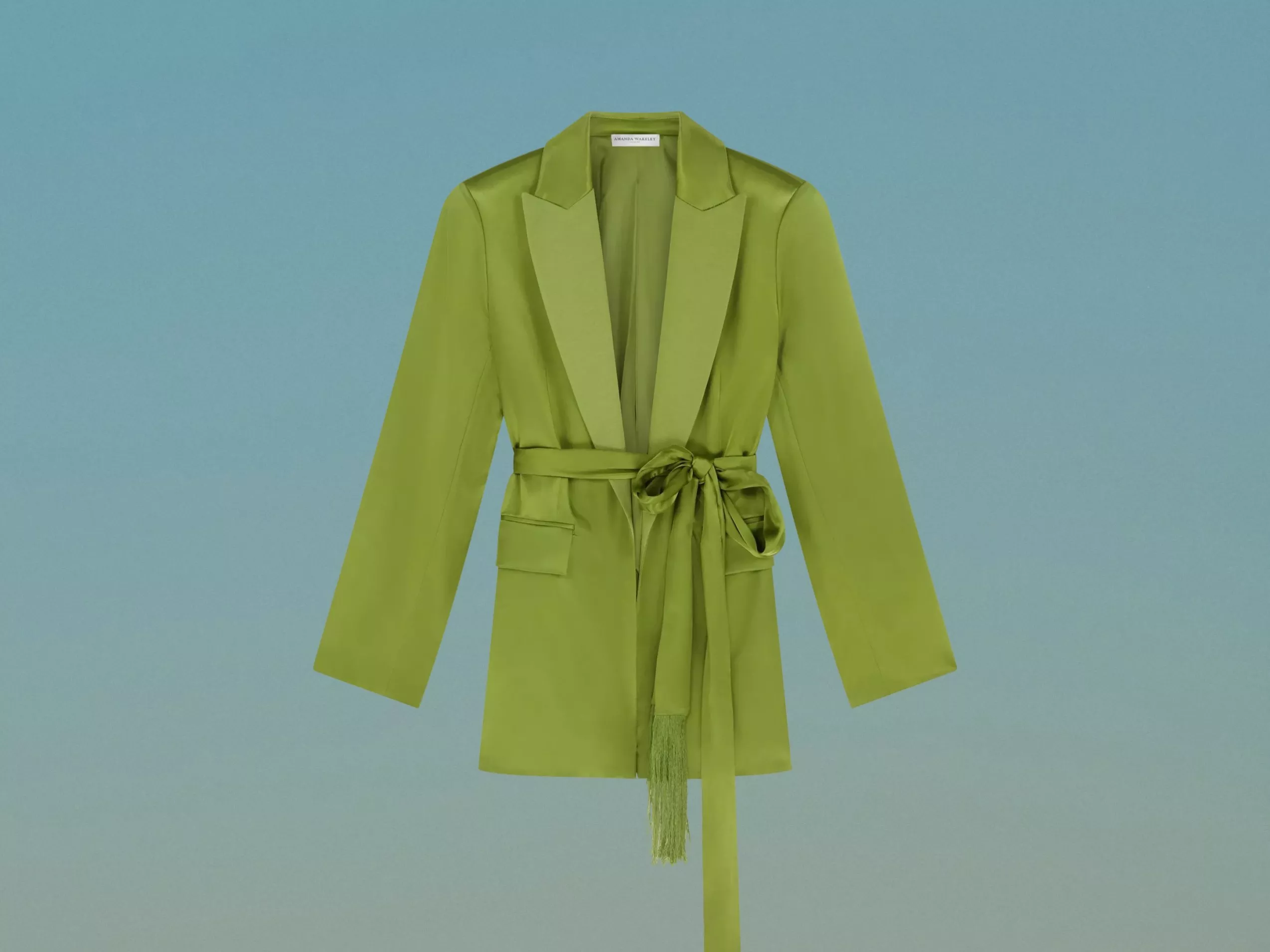 Green satin belted suit jacket with wide lapels and tie waist, front view on pale blue background