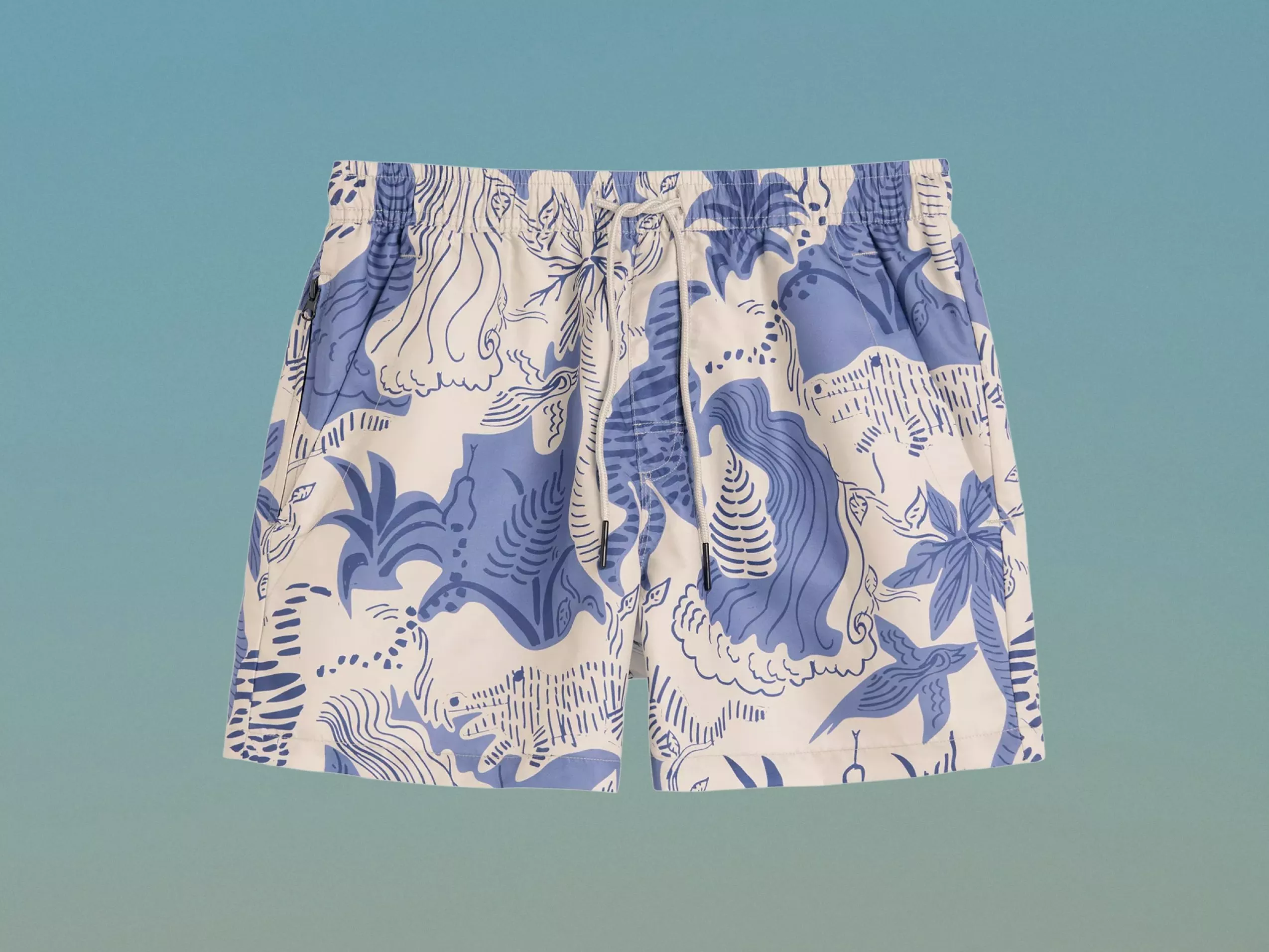 Men’s blue and white tropical print swim shorts with drawstring waist and zip pocket on a light blue background
