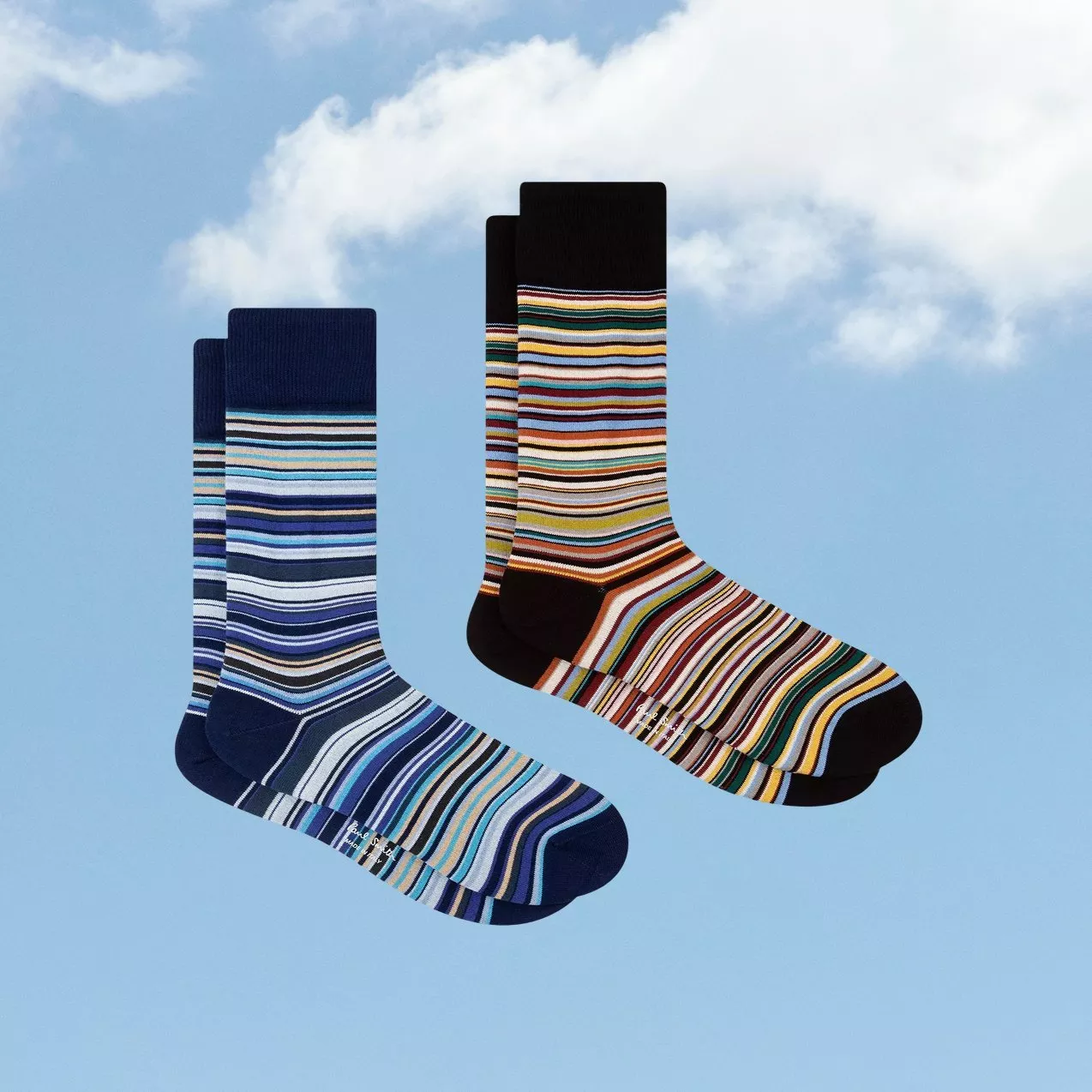 Two pairs of colourful striped men’s crew socks in blue and black, product photo on sky background