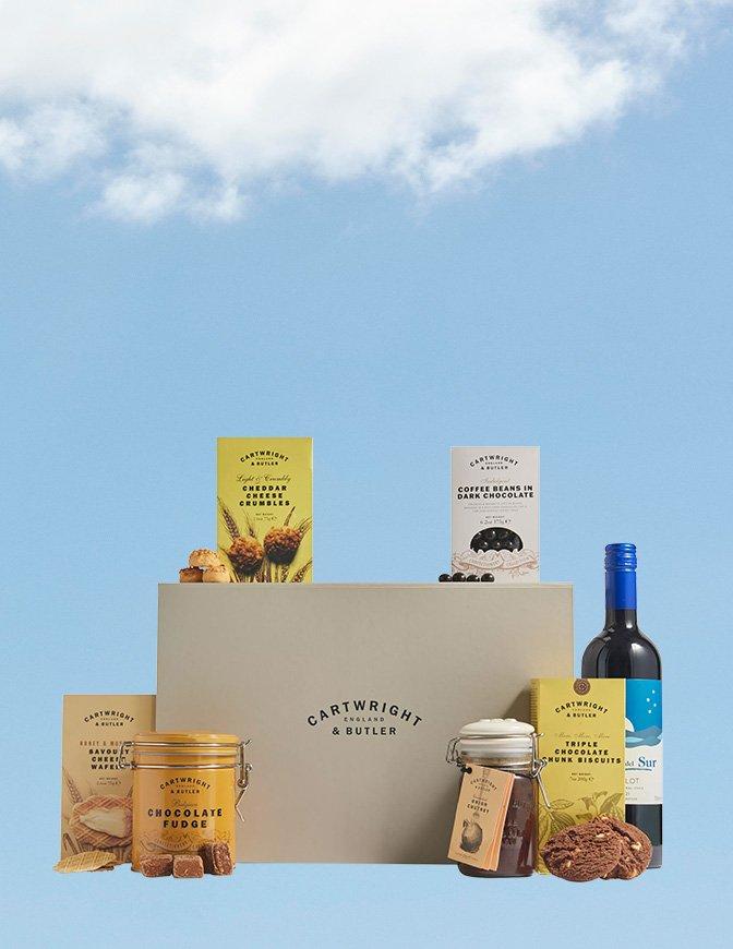 Cartwright & Butler box next to a selection of sweet & savoury snacks, and a red wine bottle