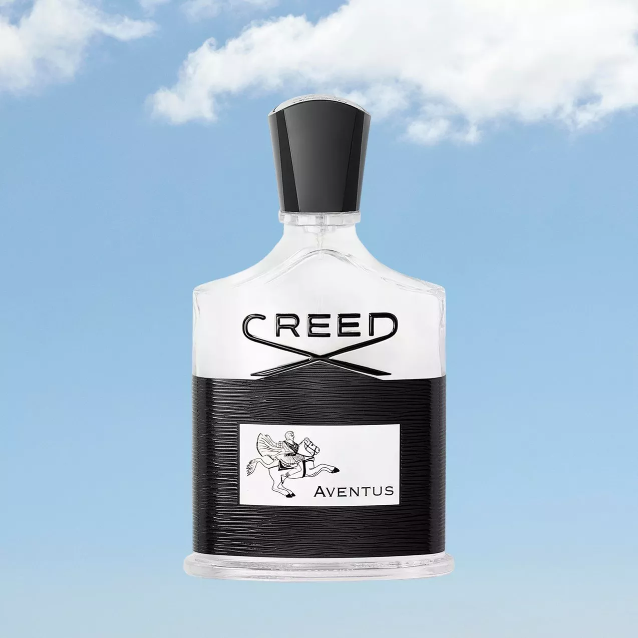 Creed Aventus men’s fragrance bottle with black cap, centred on a blue sky background with clouds