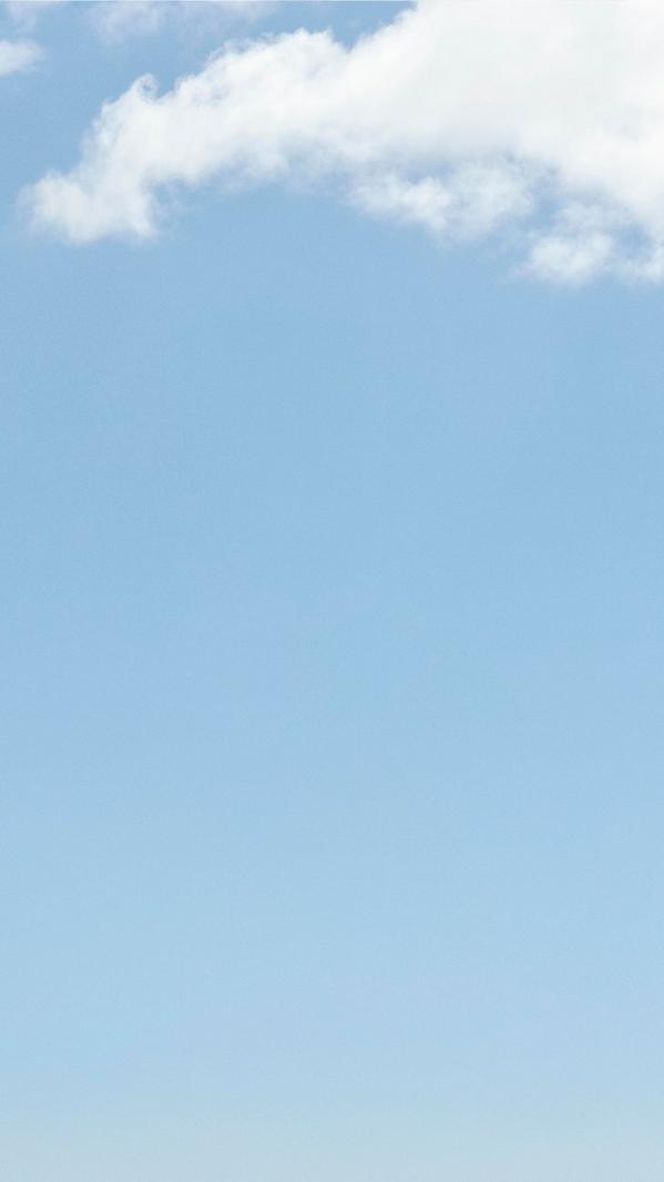 Clear blue sky with soft white clouds, minimal background for weather, nature, and outdoor summer themes