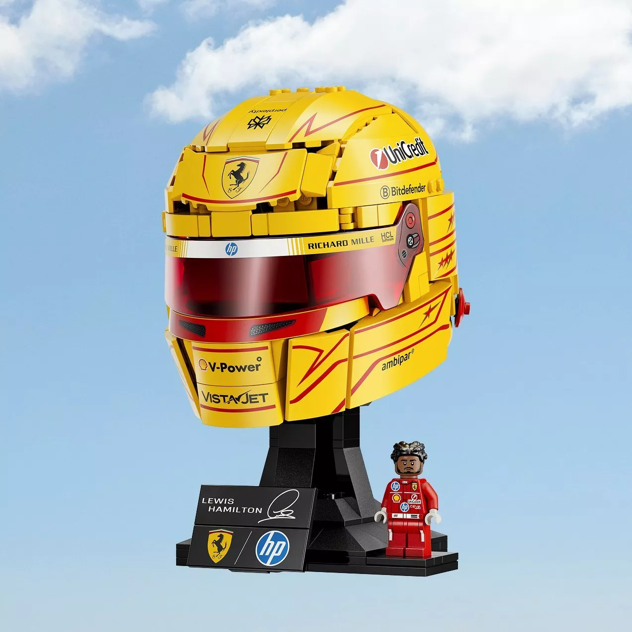 LEGO Technic Ferrari F1 Lewis Hamilton yellow racing helmet model with minifigure on display stand, sky background