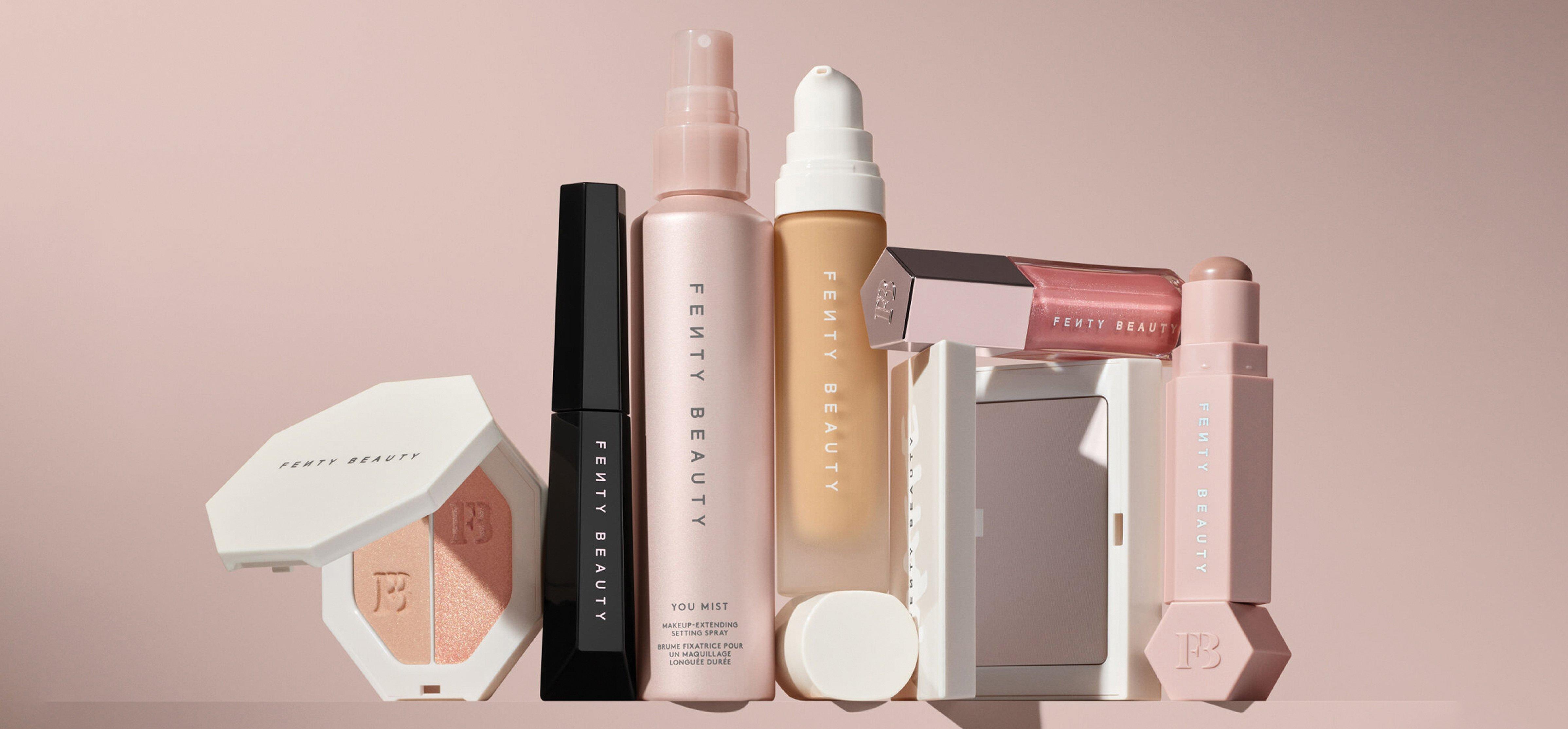 various products of fenty beauty products in a row on a pink background