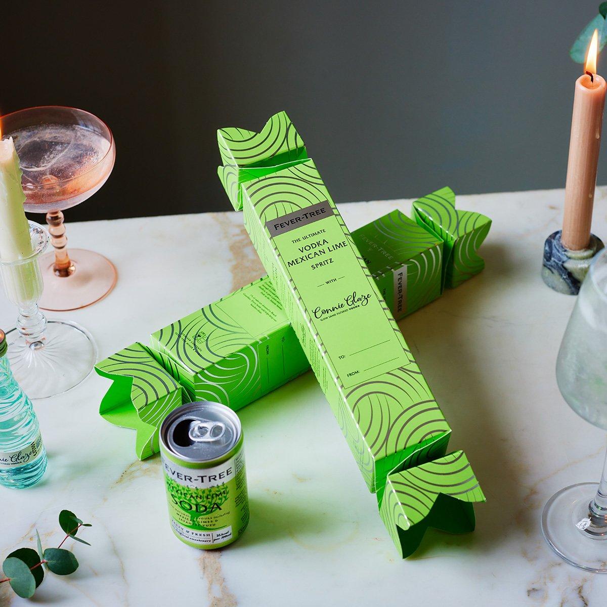 Vodka Mexican Lime cracker, and soda can displayed on a table with lit candles and drinking glasses