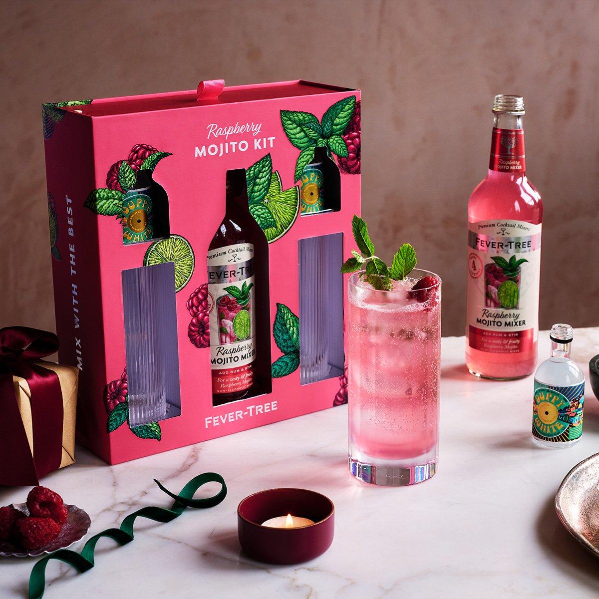Table with a raspberry mojito kit, bottle of raspberry mojito drink, and glass of mojito on display