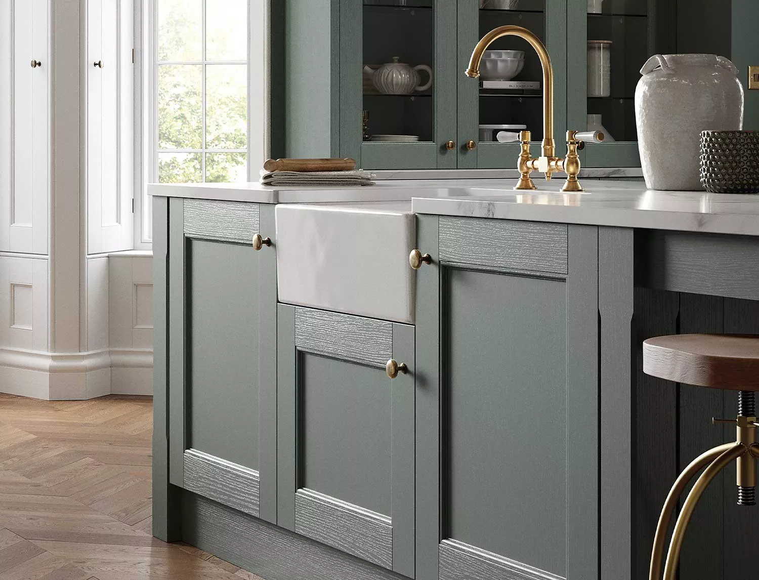Sage green kitchen with white sink and gold taps
