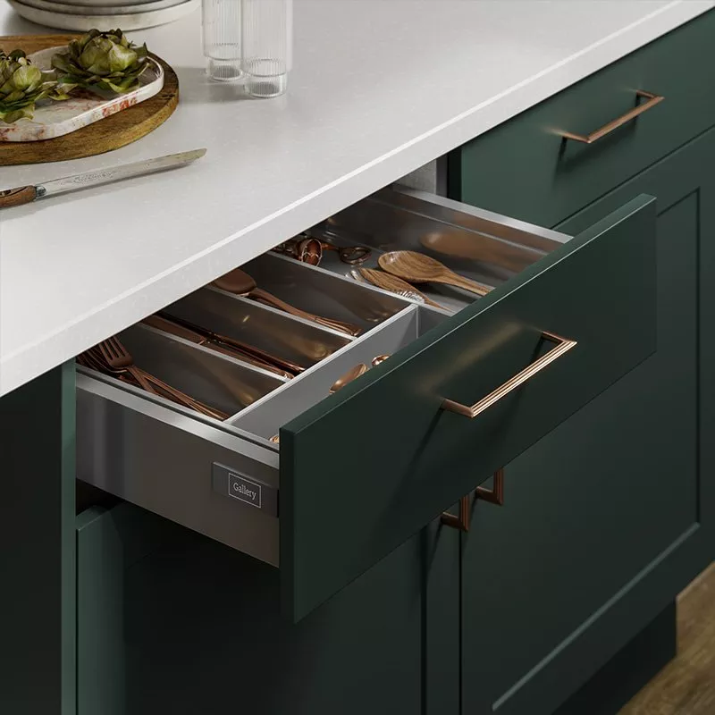 Kitchen with dark green cabinets and a cutlery drawer opened