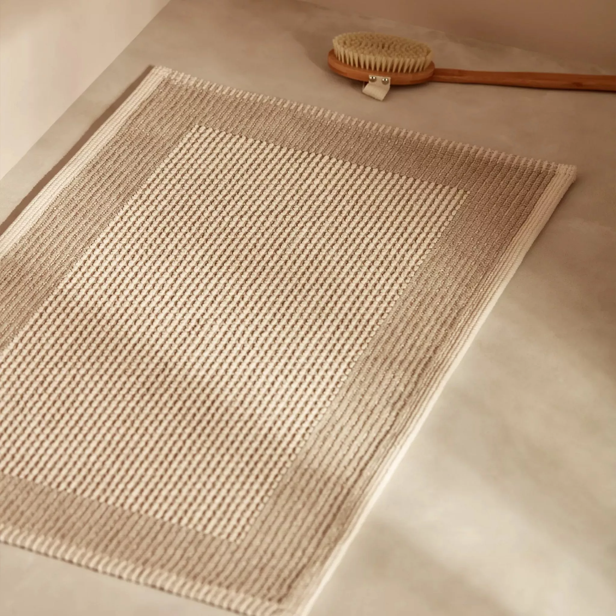 Beige bath mat on the floor 