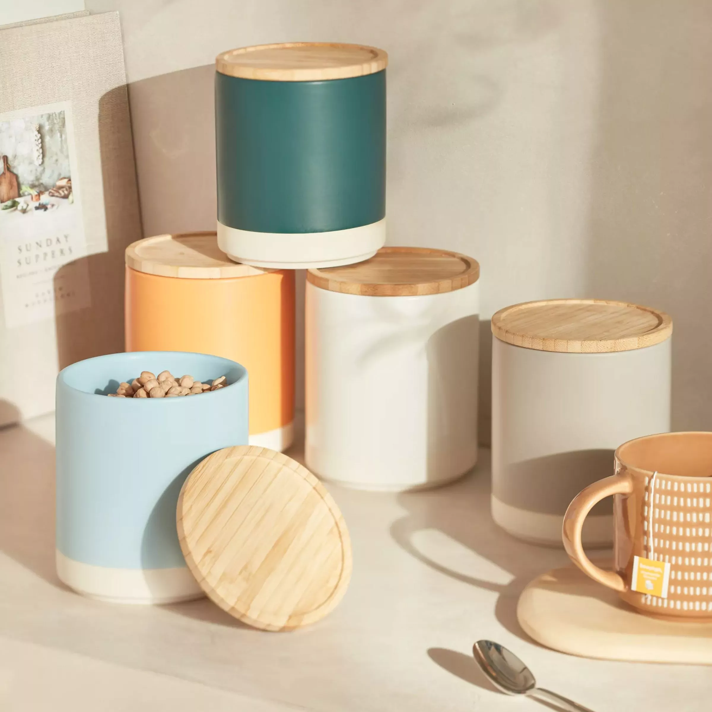 Selection or blue, orange and white cylinder storage containers with wooden lid